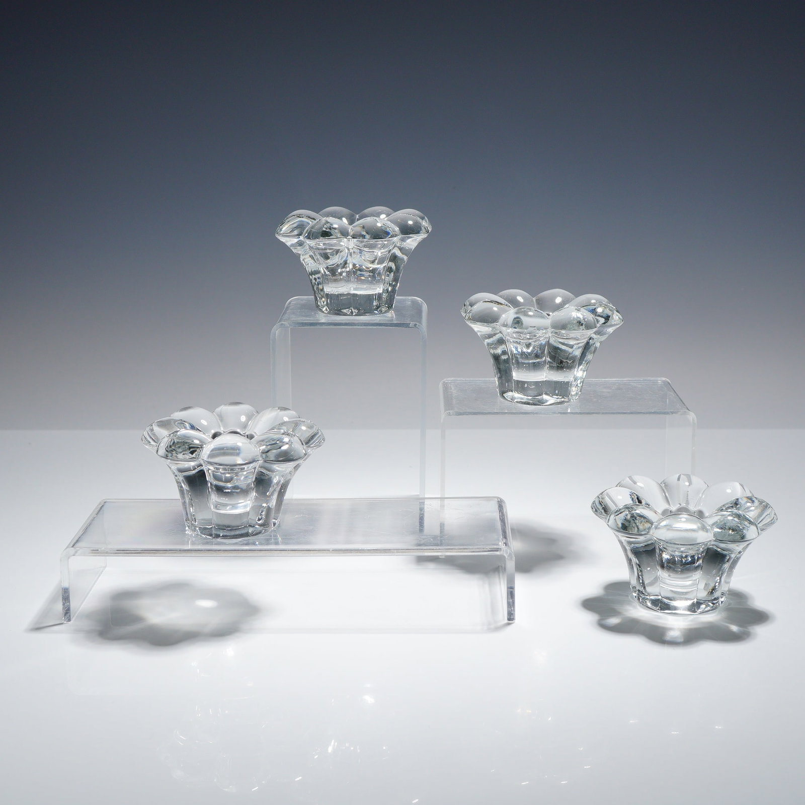4pc Heisey Glass Crystolite Candle Holder: A set of four clear crystal candle holders from Heisey Glass. Each piece is constructed of heavy, thick-walled lead crystal featuring a central well surrounded by eight rounded lobes in a floral bubbl