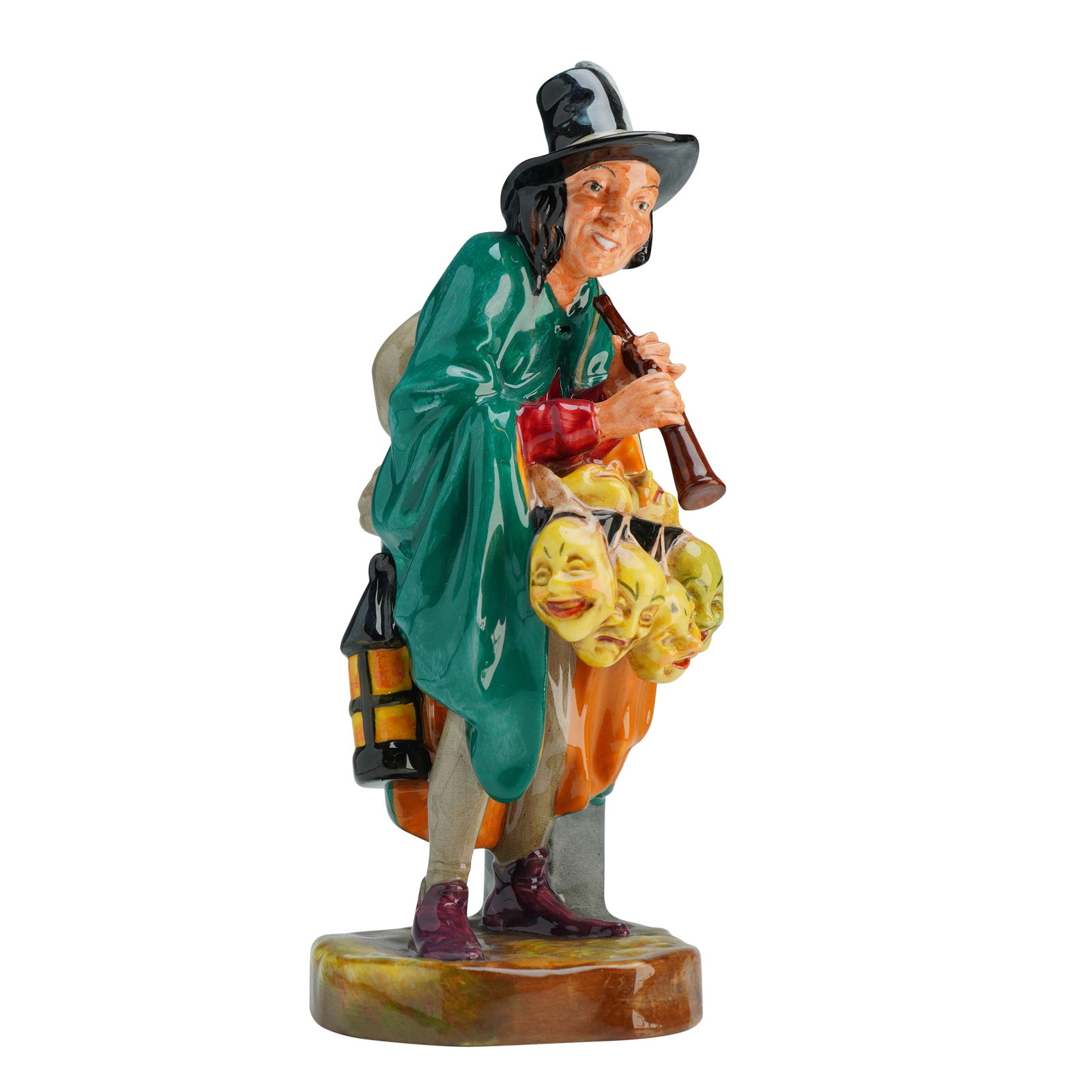 Royal Doulton Figurine The Mask Seller HN2103: This hand-painted piece depicts a male character in a wide-brimmed black hat with a white feather and a long green cloak, carrying a sack on his back, a lantern at his side, and a collection of severa