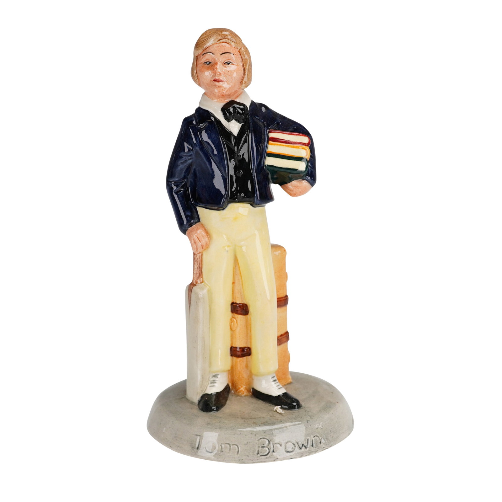 Royal Doulton Figurine Tom Brown HN2941: This Royal Doulton figurine, titled Tom Brown HN2941, is a hand-painted porcelain figure from the Children's Literature series. Designed by William Harper and issued in 1982, the piece depicts a schoo