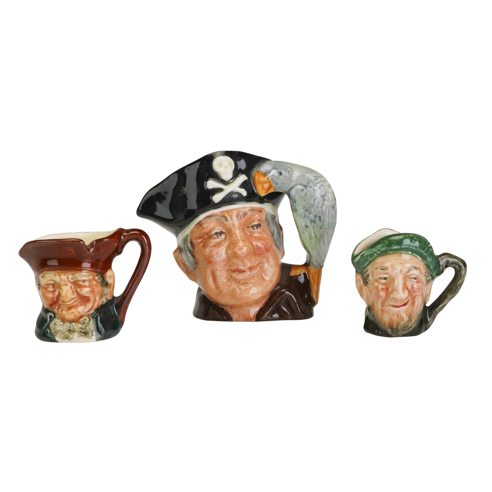 3pc Royal Doulton Mini and Tiny Character Jugs, Old Charley, Long John Silver, and Auld Mac: This lot includes three Royal Doulton fine glazed earthenware character jugs: Old Charley (D6144), Long John Silver (D6512), and Auld Mac (D6257). The collection features one miniature and two tiny-si