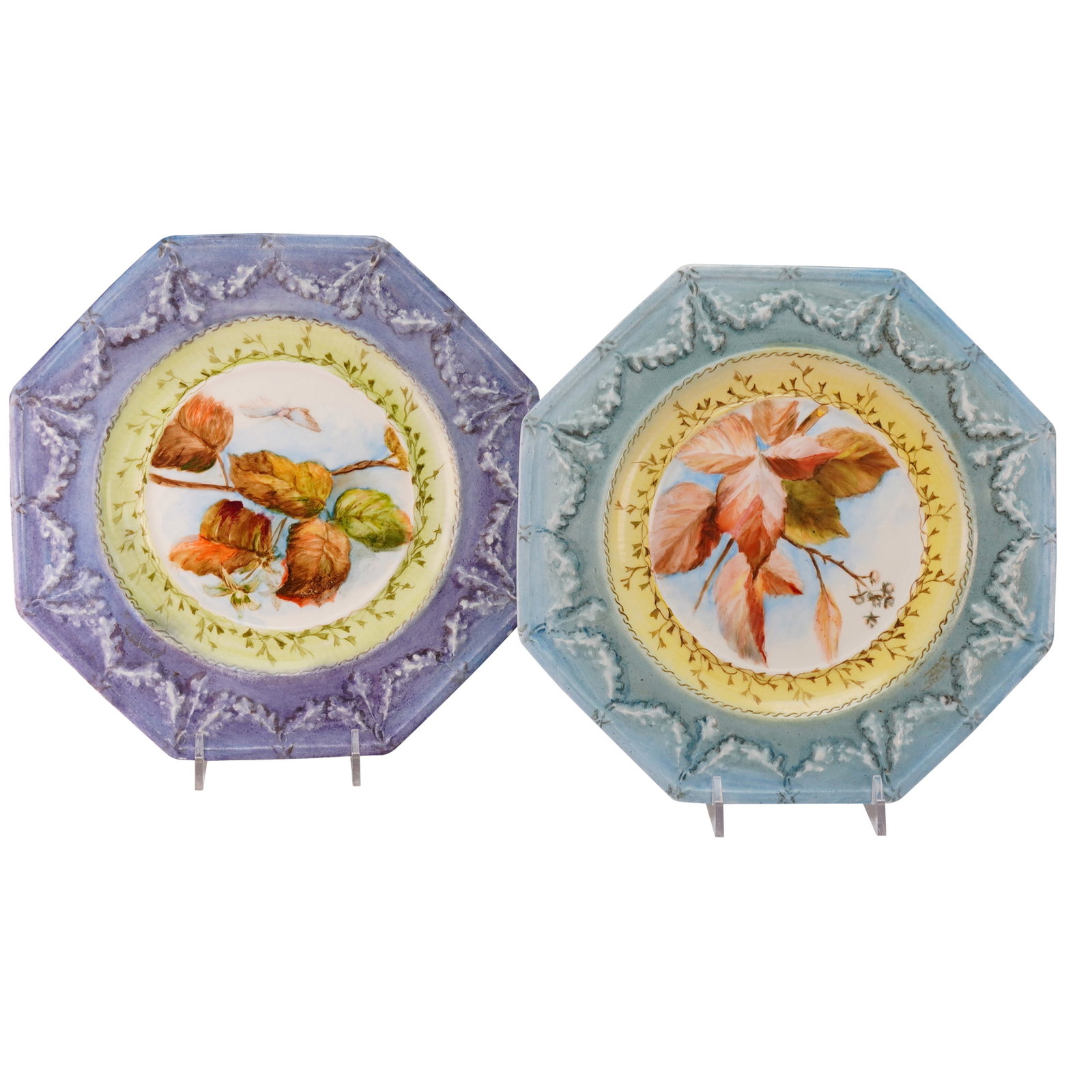 2pc Wedgwood Hand Painted Victorian Majolica Plates: The collection features leaf designs with heavy relief molding applied to the rim. One plate is finished in a purple/lavender glaze, and the other in a light blue/teal glaze. The central well of each 