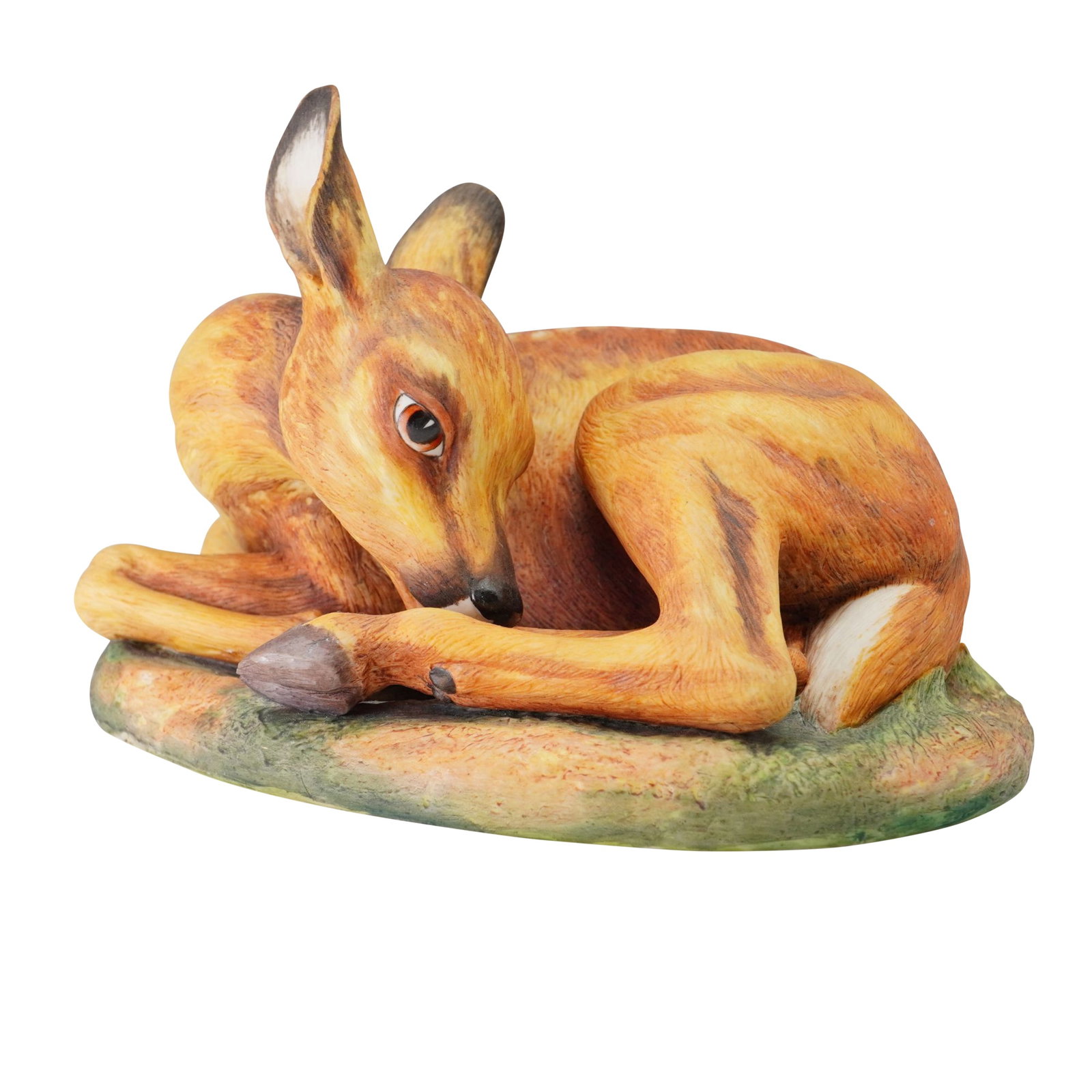 Boehm England Porcelain Figurine Fallow Deer 200-33: The naturalistic, hand painted study depicts a young deer curled in a resting position on an oval, textured base modeled to resemble grass and earth. The piece is finished in realistic tones of tan an