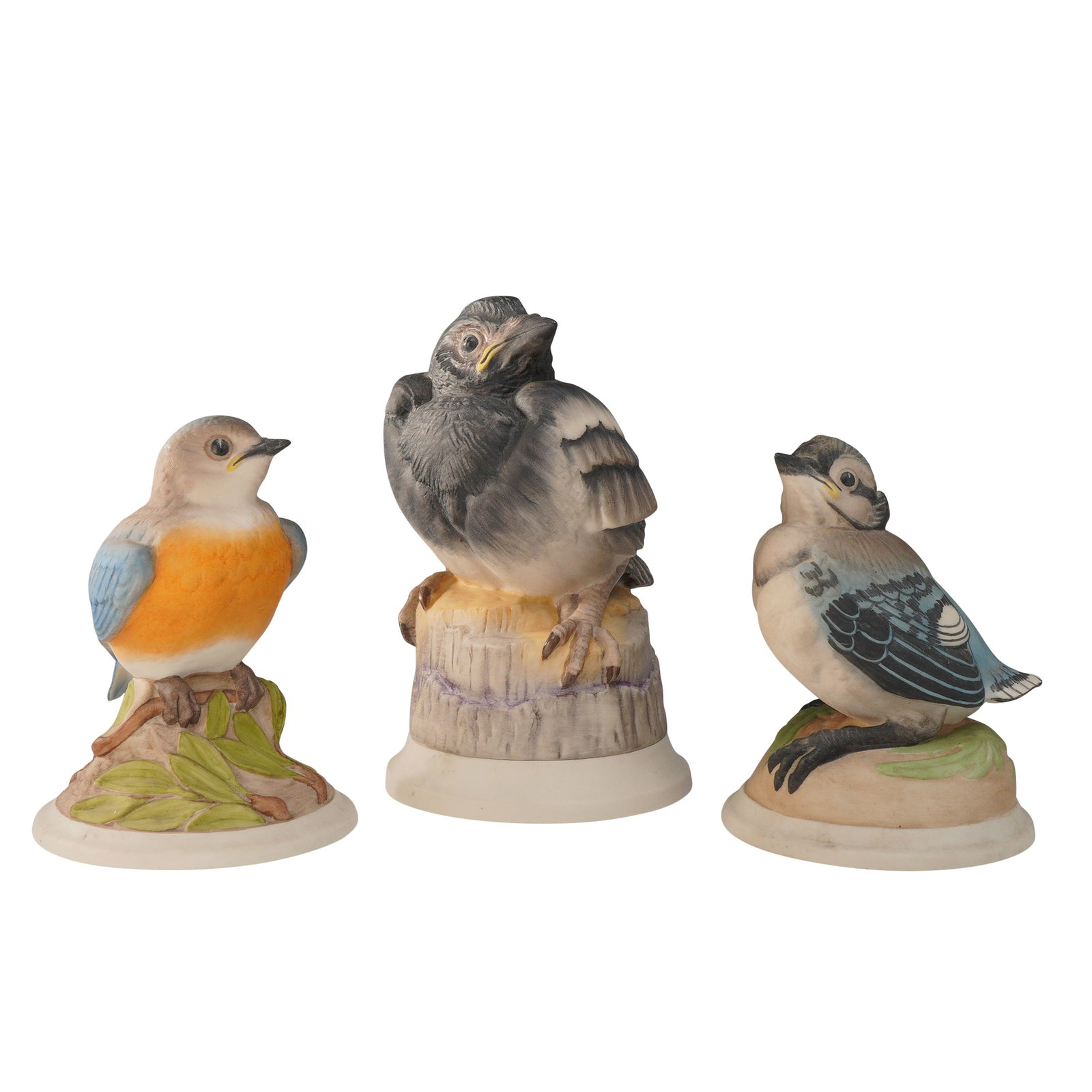3pc Boehm Porcelain Figurines, Baby Blue Bird, Fledgling Magpie, and Baby Blue Jade: The collection includes Baby Blue Bird (442), a young bluebird with a bright orange breast and soft blue wings, perched on a branch accented with green leaves. Collection also includes, Fledgling Magp
