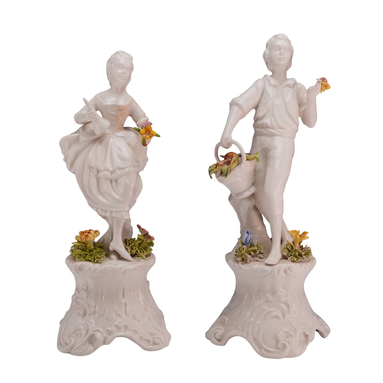 2pc Bassano Porcelain Figurines of a Pastoral Couple: A pair of glazed white porcelain figurines depicting a young man and woman in 18th-century pastoral attire, produced in Bassano del Grappa, Italy. The male figure is depicted holding a single flower i