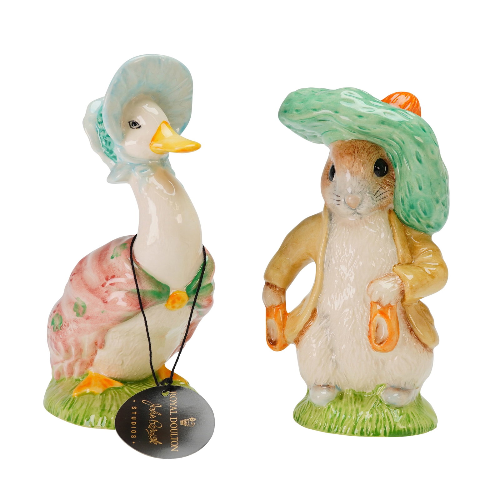 2 Royal Albert Beatrix Potter Figurines Benjamin Bunny & Jemima Puddleduck: Each figure is crafted from glazed ceramic with a high-gloss finish and stands on a textured grassy base. The Benjamin Bunny figure is depicted in a tan jacket and a large green tam-o-shanter. The und