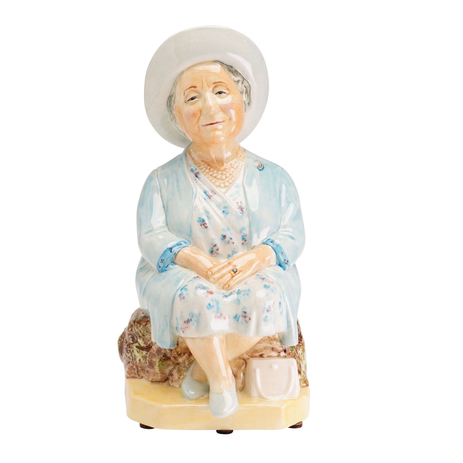 Kevin Francis Ceramics Commemorative Character Jug, The Queen Mother -Blue: A limited edition glazed ceramic character jug produced by Kevin Francis Ceramics, featuring a portrait of Her Majesty Queen Elizabeth The Queen Mother. The figure is seated on a rocky outcrop, dresse
