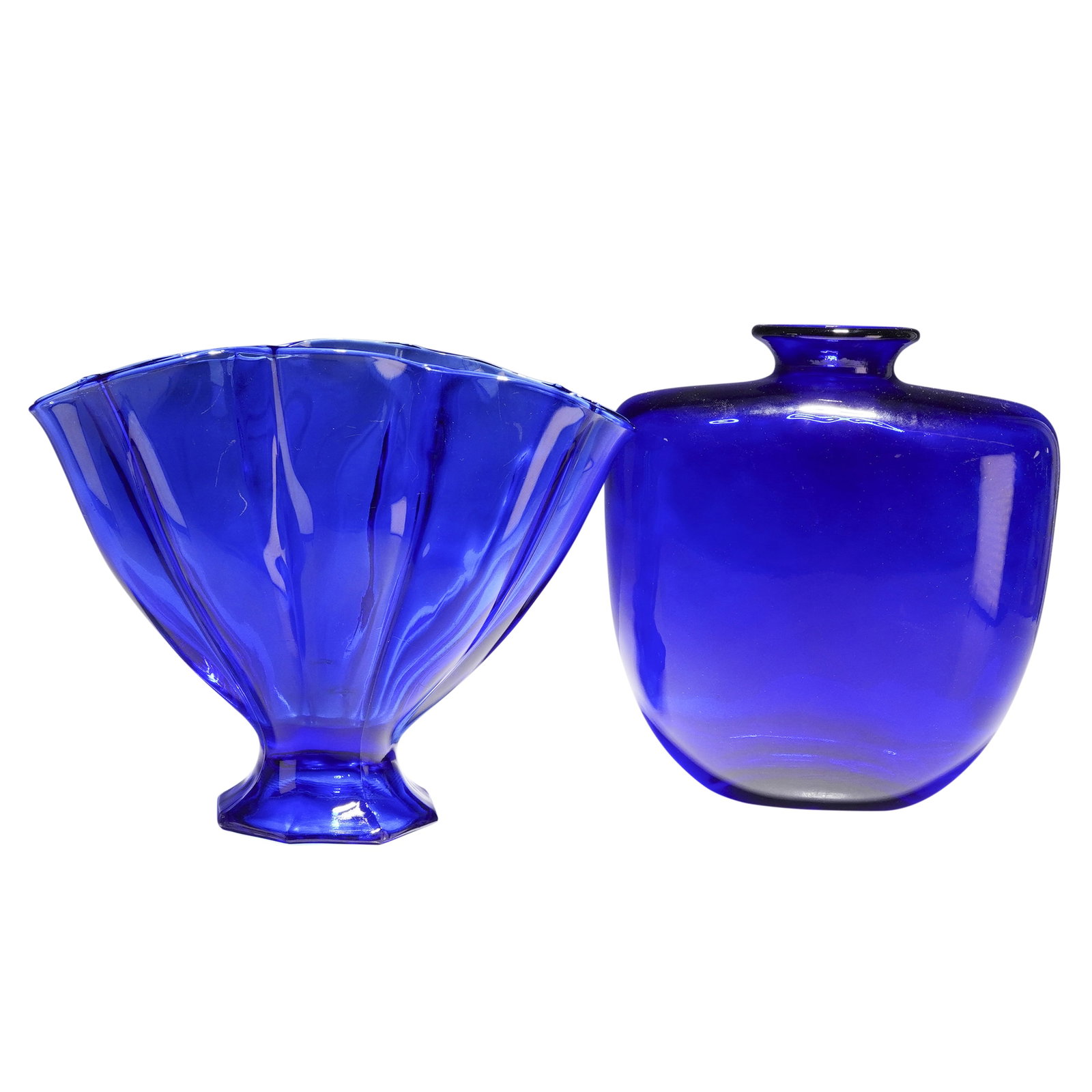 Two Cobalt Blue Glass Vases: This lot consists of two decorative vases in deep cobalt blue glass. The first item is a pressed glass vase featuring a flared, ruffled rim and a vertically ribbed body that tapers down to a short ped