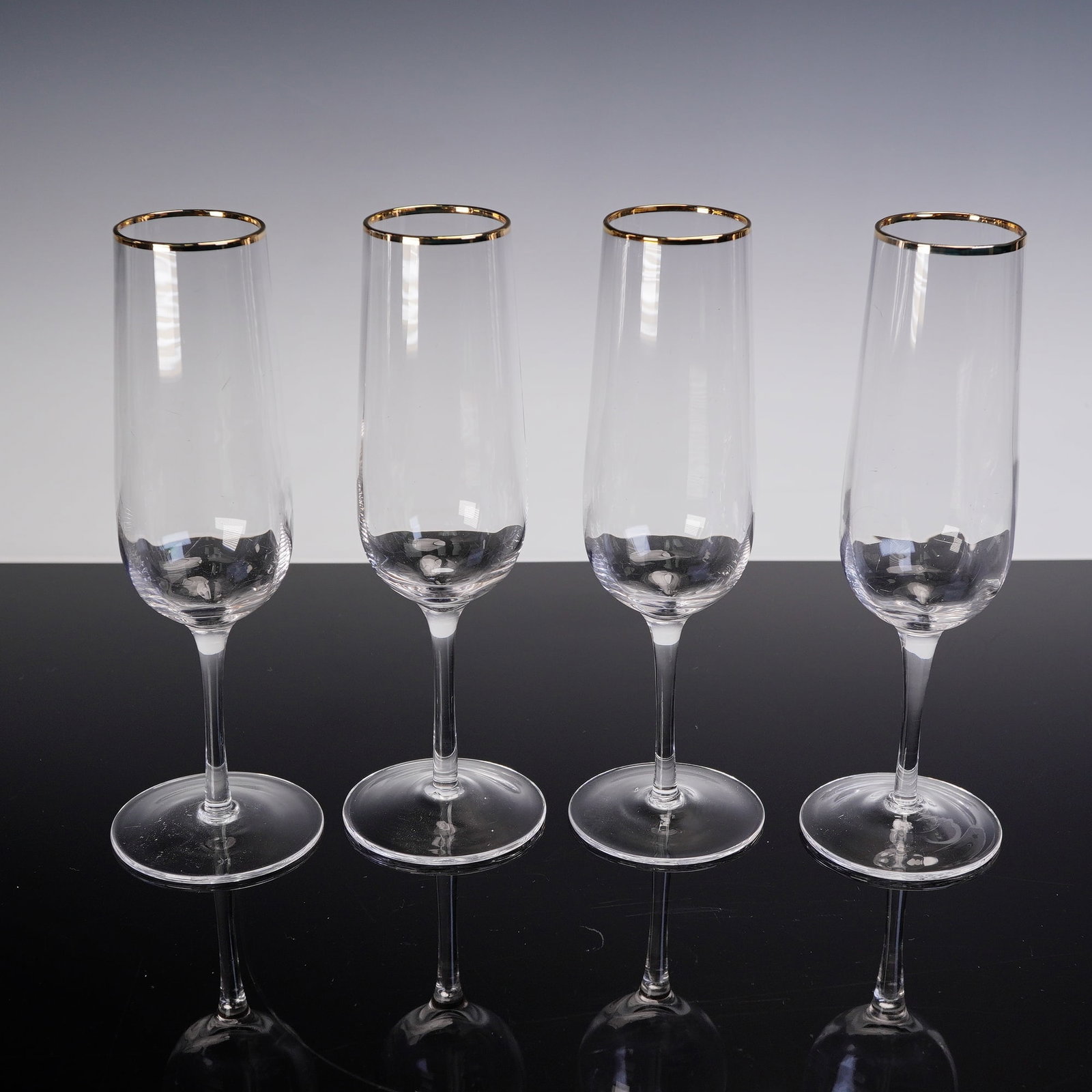 4pc Martha Stewart Champagne Glass Set with Gold Rim: Set of four clear glass champagne flutes, each featuring a slender stem and elongated bowl. The glasses are accented with a gold band around the rim. Dimensions: 3"W x 9"H Manufacturer or Brand: Marth