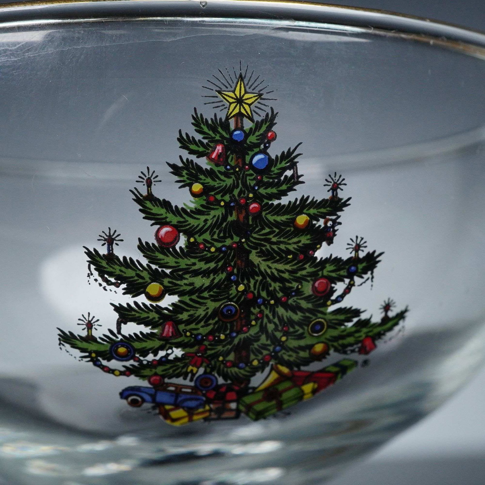 4pc Cuthbertson Sherbet Glasses, Christmas Tree: Set of four clear sherbet glasses each featuring an applied festive design depicting a decorated evergreen with presents beneath, the rims trimmed with a narrow gilt band. Dimensions: 3"W x 4.75"H Dat