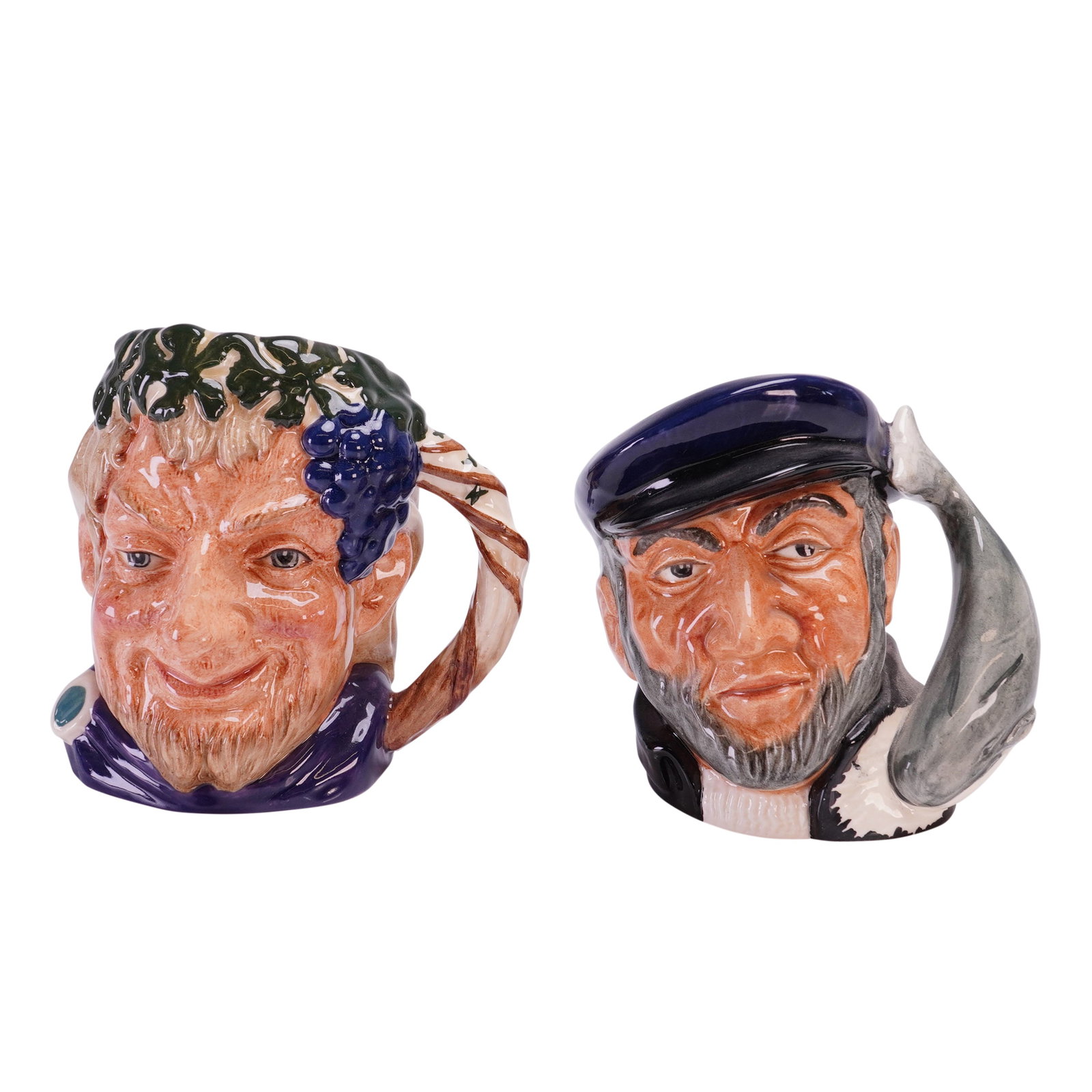 2pc Royal Doulton Small Character Jugs, D6505 and D6506: Small character jugs featuring Bacchus and Captain Ahab. These 2pc Royal Doulton jugs are constructed with relief molding and finished with a high-gloss glaze. The Bacchus jug, model D 6505, depicts t