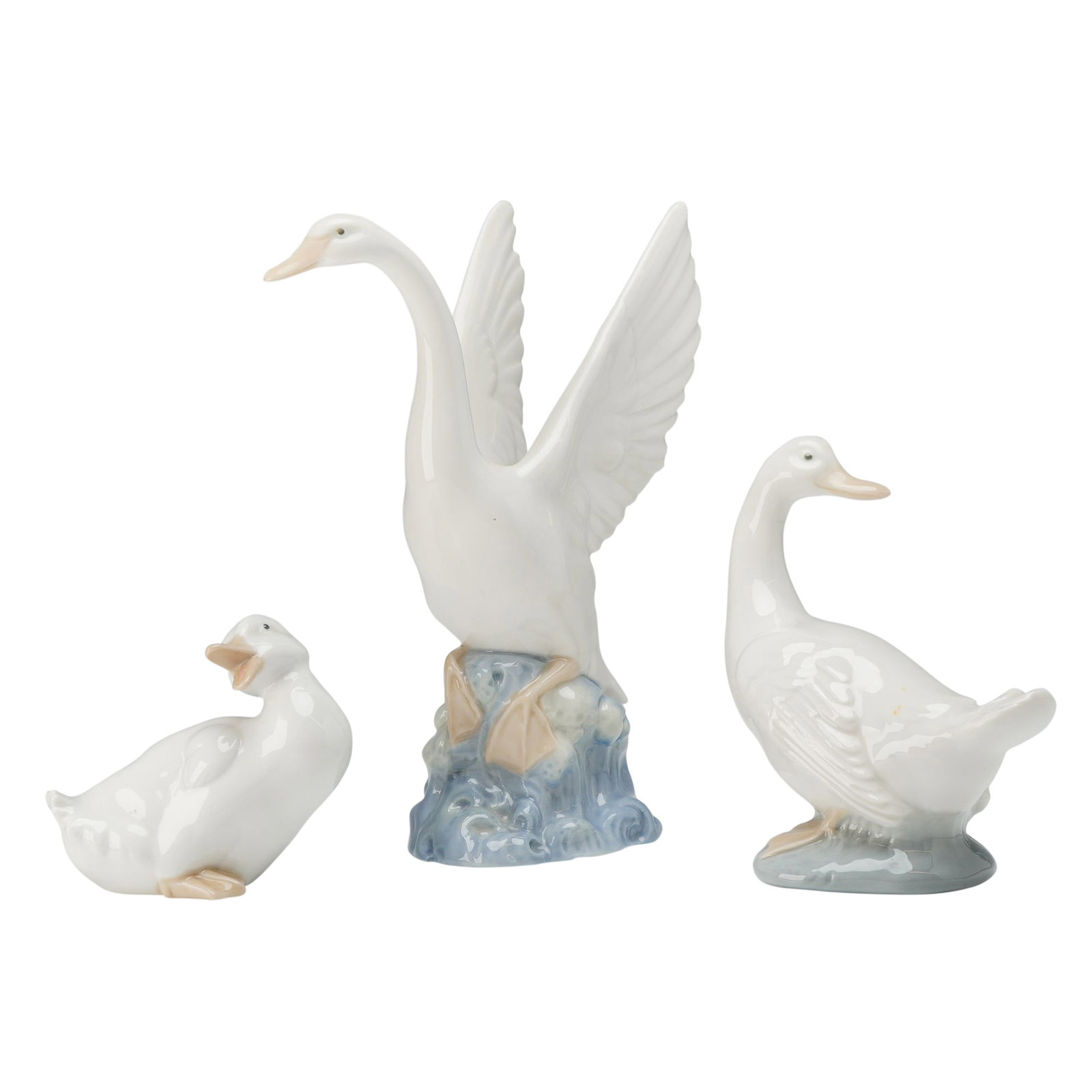 3pc Nao by Lladro Porcelain Figurines, Swan and Ducks: Glazed porcelain figurines with Swan spreading wings, duck turning head and duck speaking. Nao by Lladro backstamp on bases. Dimensions: Largest piece 3.25"L x 3.25"W x 8"H Manufacturer or Brand: Nao 