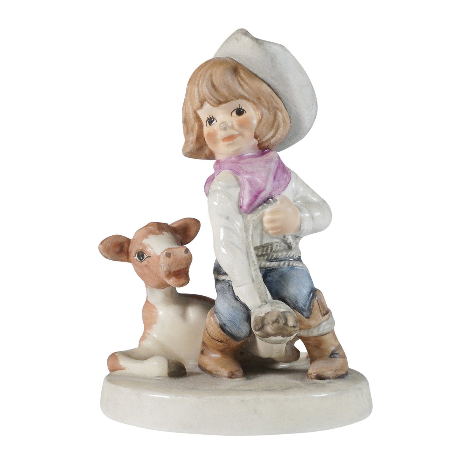 Goebel Figurine, Cowgirl Rodeo: This Goebel figurine, titled Cowgirl Rodeo, captures a charming Western-themed scene of a young cowgirl kneeling beside a cow, dressed in a white cowboy hat, pink bandana, and denim jeans. The figurin