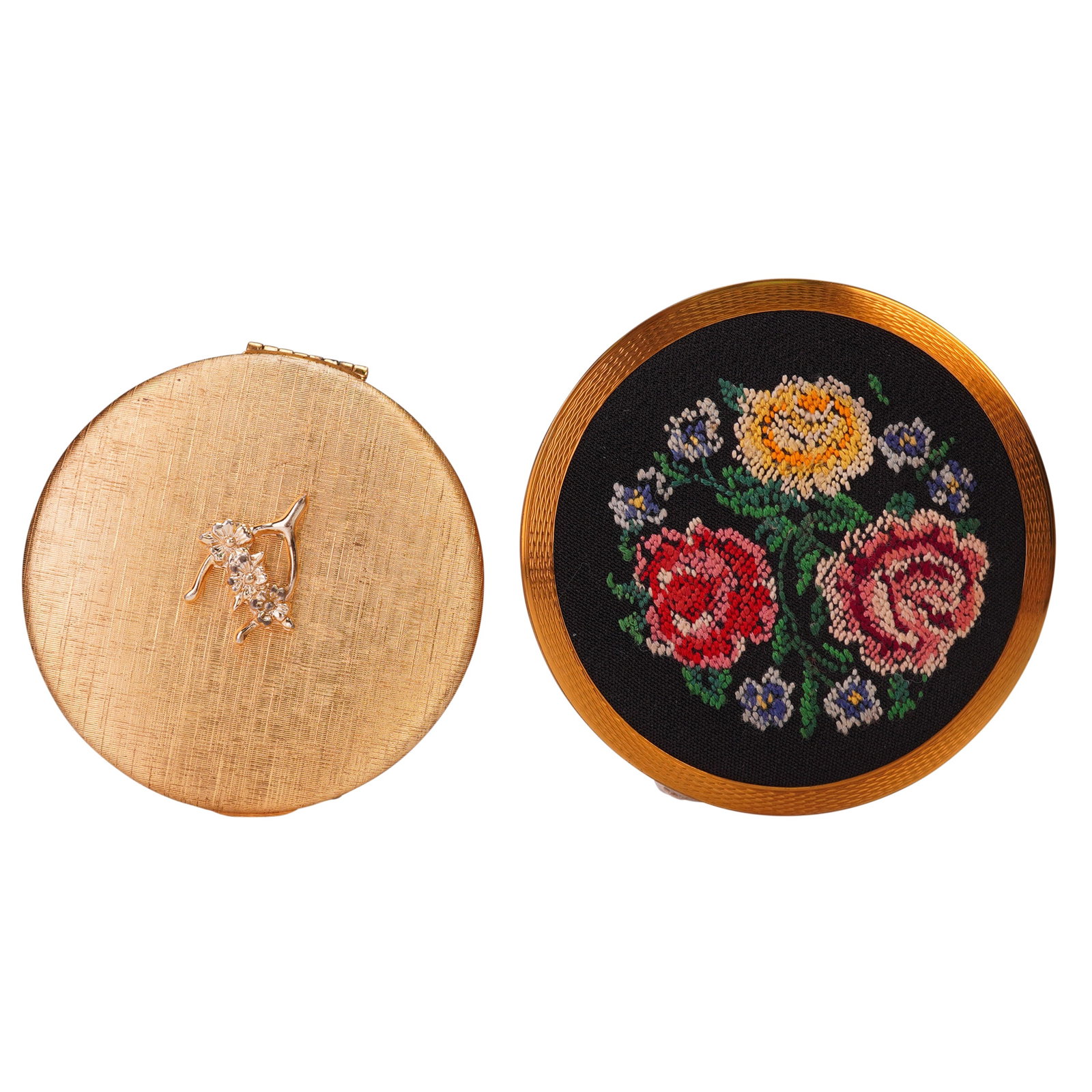 2pc Vintage Stratton and Dubarry Compact Cases: Pair of distinctive round compacts including a Stratton England compact with gold-tone casing, black enamel back, and floral petit point embroidery on the lid, and a Dubarry CloudSilk compact in gold-