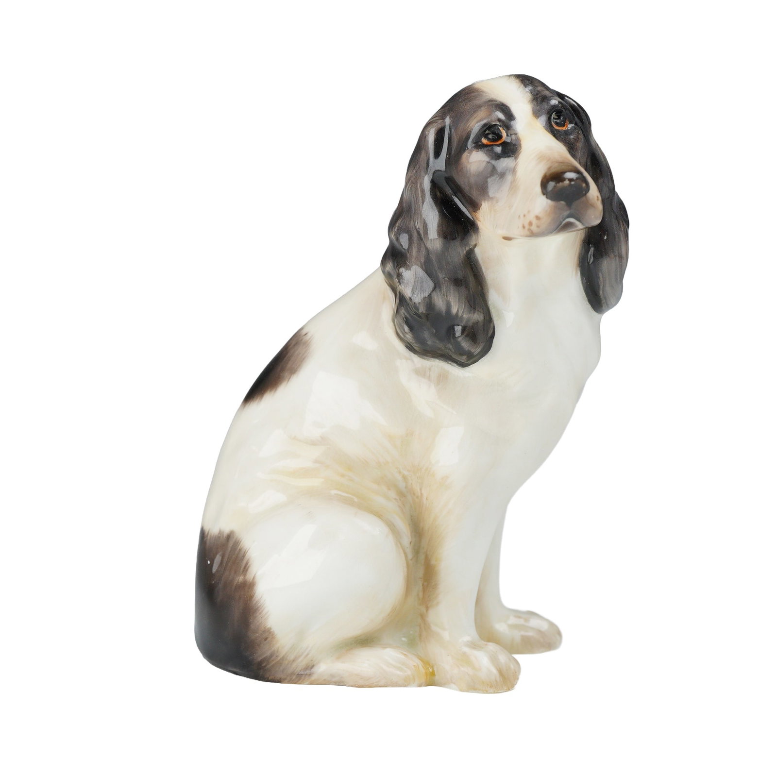 Royal Doulton Dog Figurine, King Charles Spaniel: This Royal Doulton porcelain figurine depicts a seated King Charles Spaniel. The figure is crafted from glazed porcelain and features hand-painted black and white markings with brown eyes. The undersi