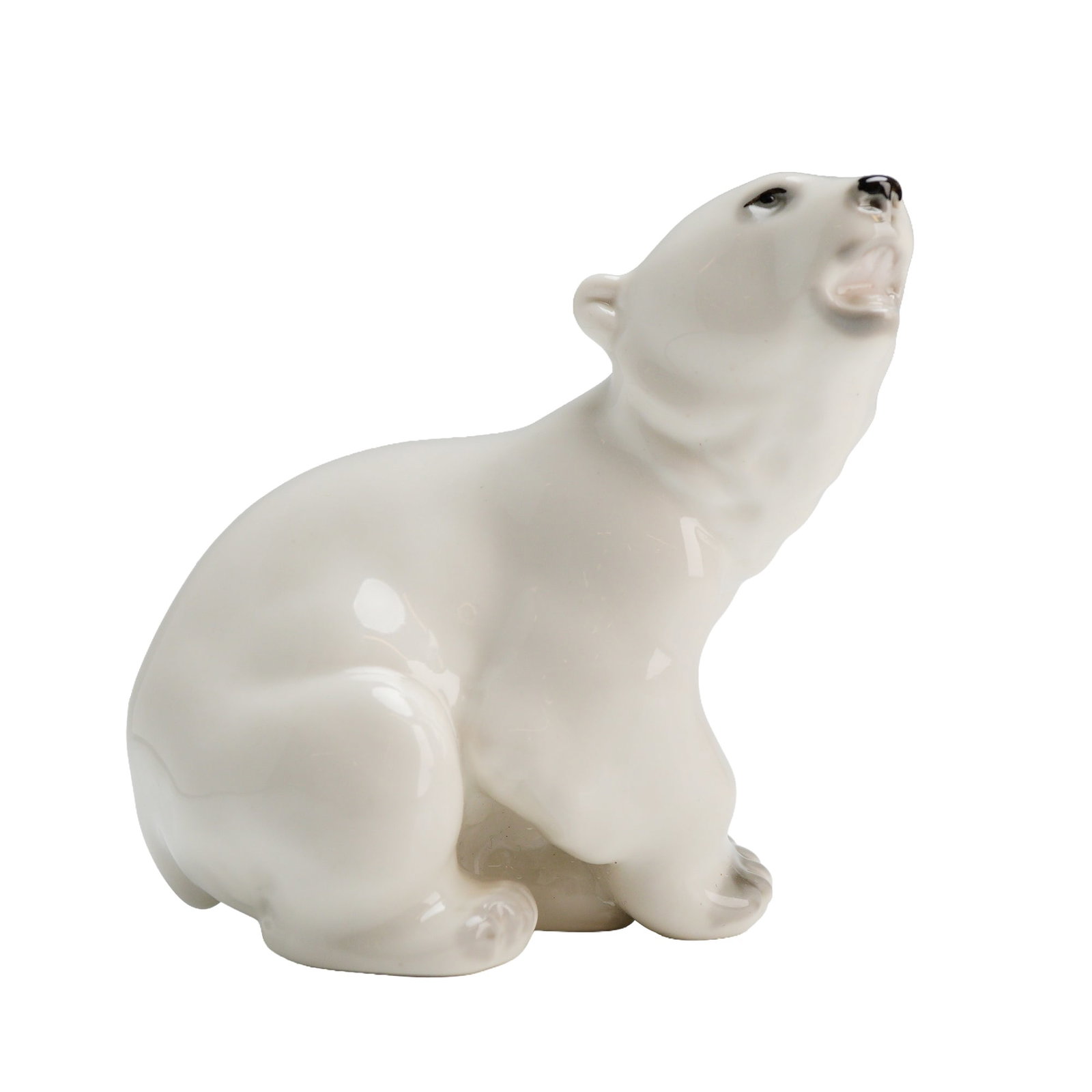 Lomonosov Porcelain Figurine of a Polar Bear Cub: A porcelain figurine attributed to the Lomonosov Porcelain Factory (LFZ). The piece depicts a single seated polar bear cub looking upward with its mouth open, rendered in a naturalistic style. The fig