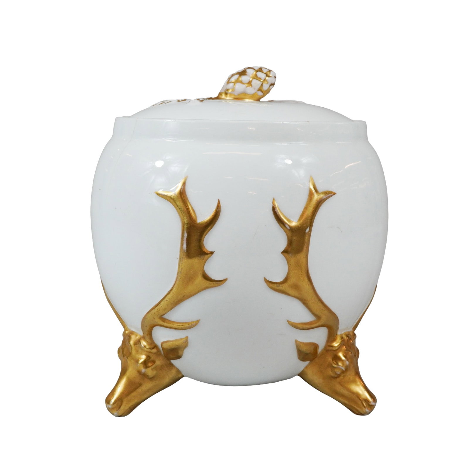 Wedgwood White and Gilded Stag and Pinecone Porcelain Lidded Jar: A Wedgwood porcelain lidded jar of bulbous form supported on three relief-molded tripod feet. The decorative scheme features three gilded stag heads that serve as the feet, with their antlers extendin