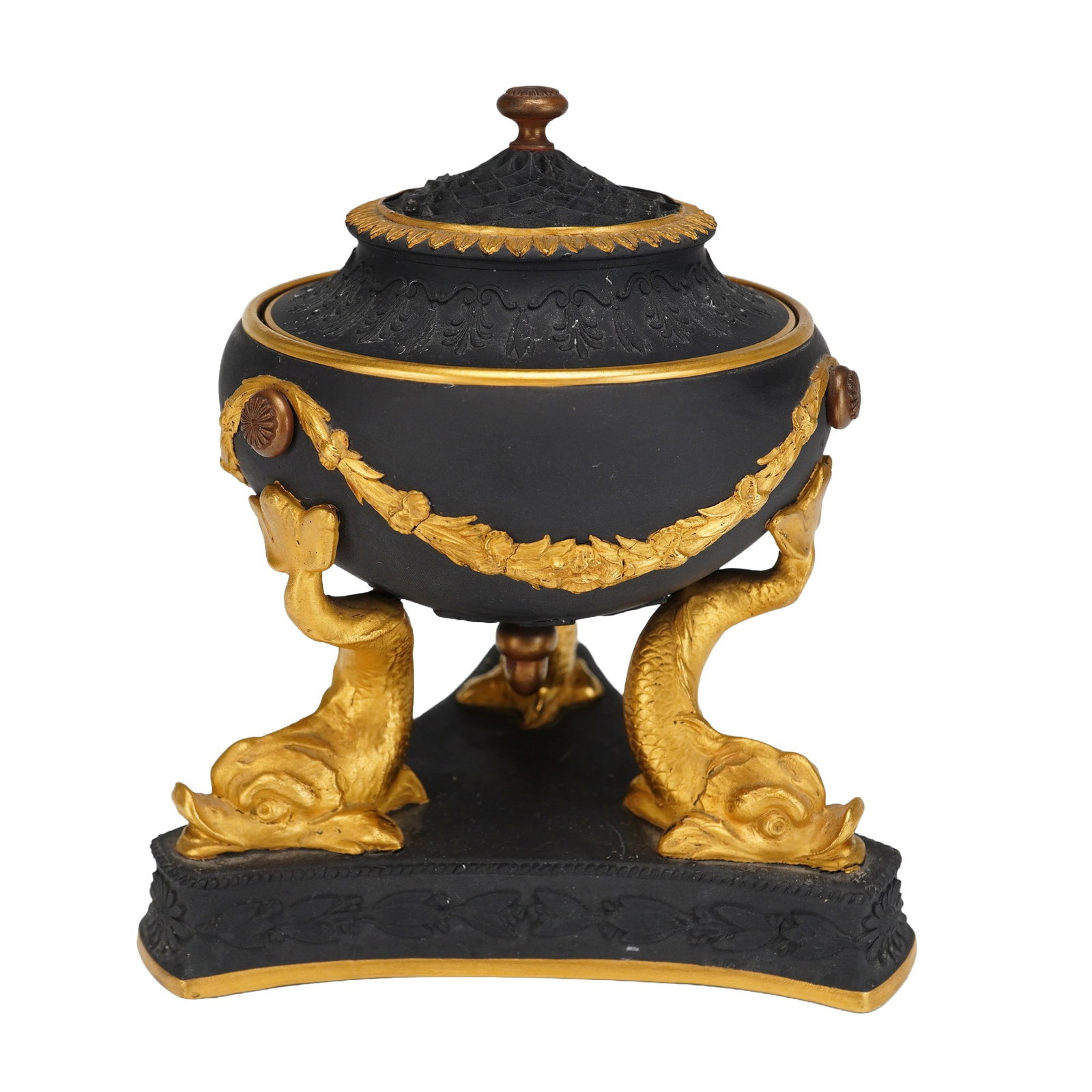 Wedgwood Gilt and Bronzed Black Basalt Tripod Pastille Burner: A Wedgwood black basalt pastille burner dating to circa 1895. The ovoid body is decorated with relief-molded gilded floral festoons and rosettes, supported by three legs modeled as dolphins with a gil