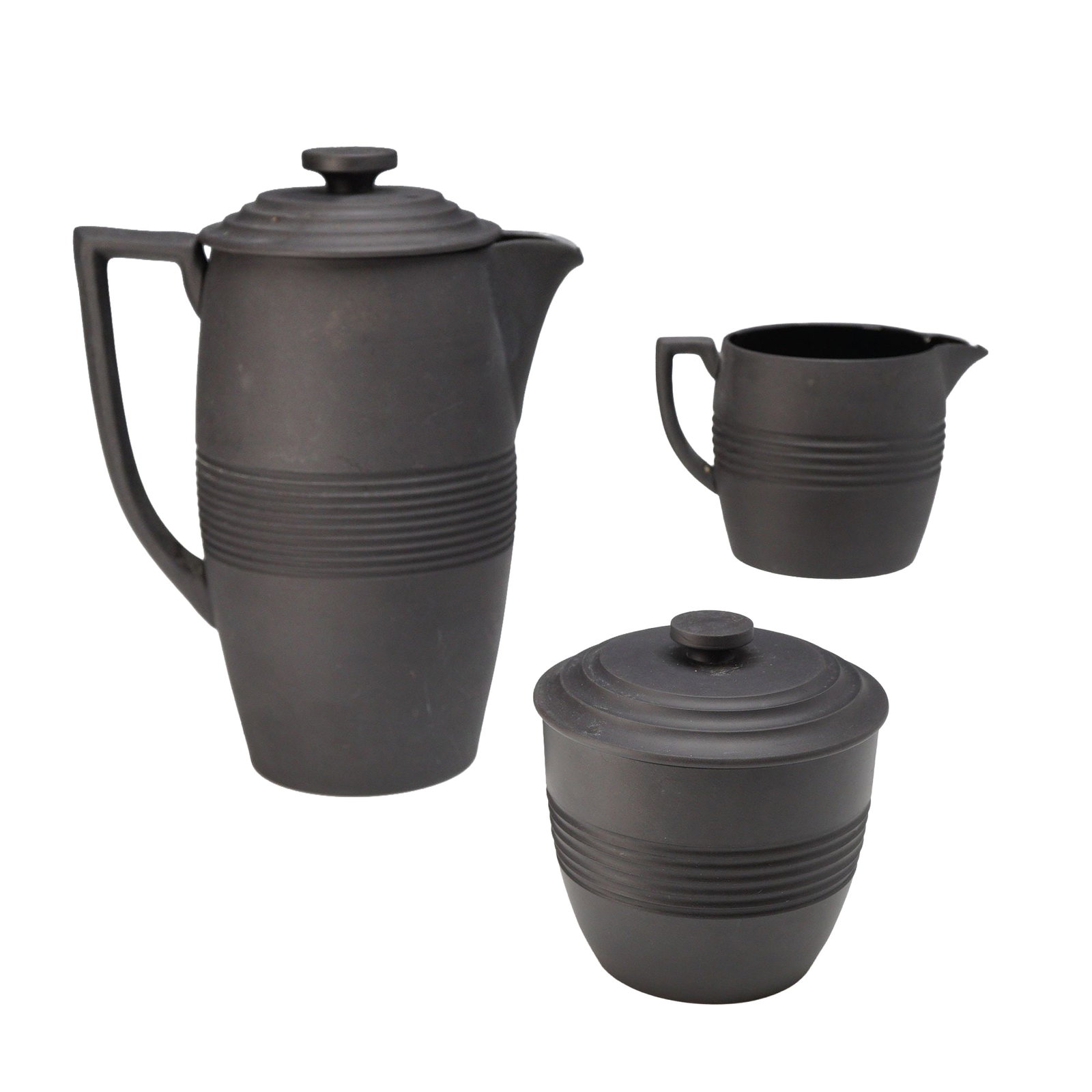 Three Piece Wedgwood Black Basalt Coffee Set by Keith Murray: This three piece set of Wedgwood black basalt stoneware was designed by Keith Murray during the 1930s. The collection consists of a tall tapered coffee pot with lid, a lidded sugar bowl, and a cream j