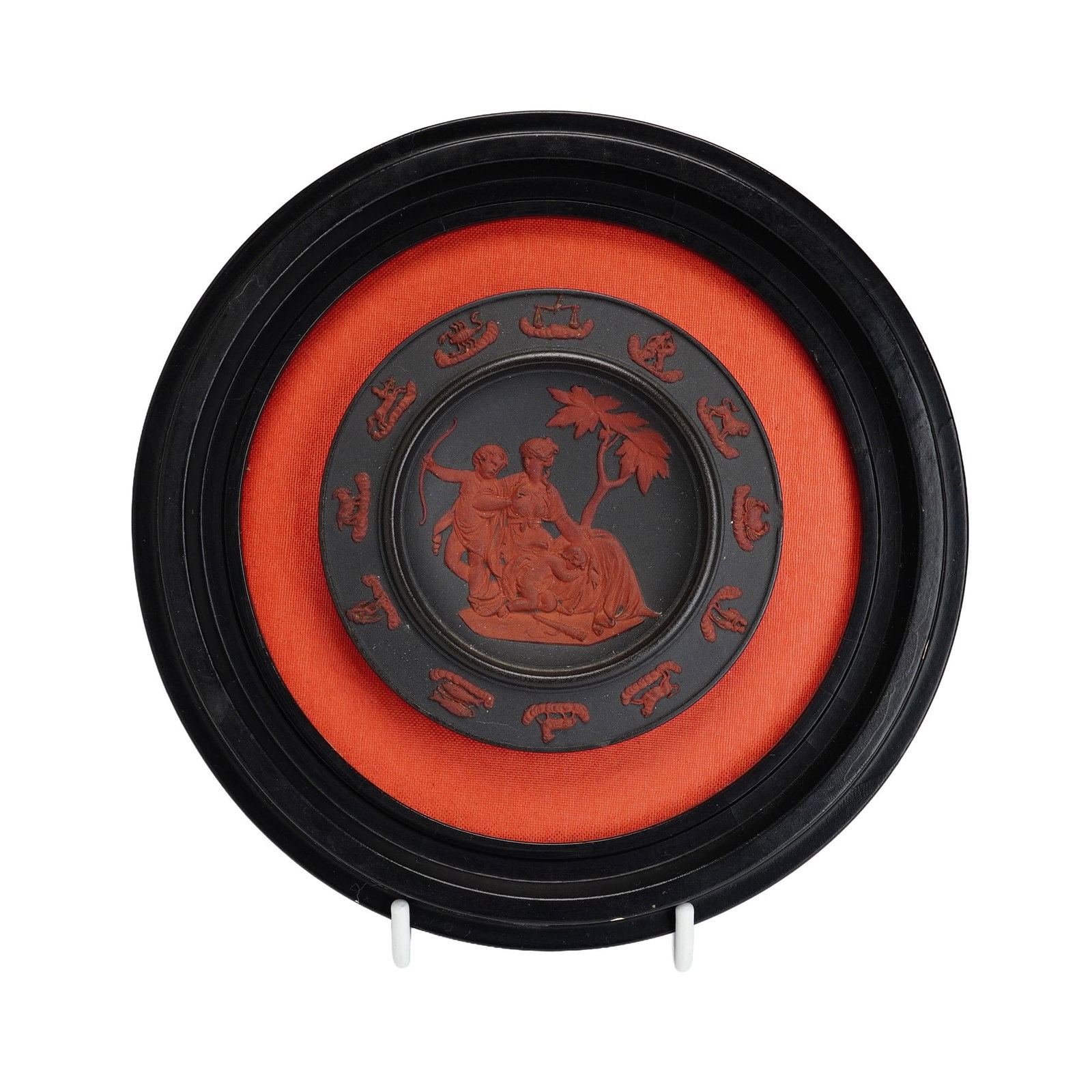 Wedgwood Rosso Antico and Black Basalt Birth and Dipping of Achilles Zodiac Plaque: A circular Wedgwood wall plaque featuring a black basalt stoneware body with applied terracotta-colored rosso antico relief decoration. The central circular reserve depicts a Neoclassical scene identi