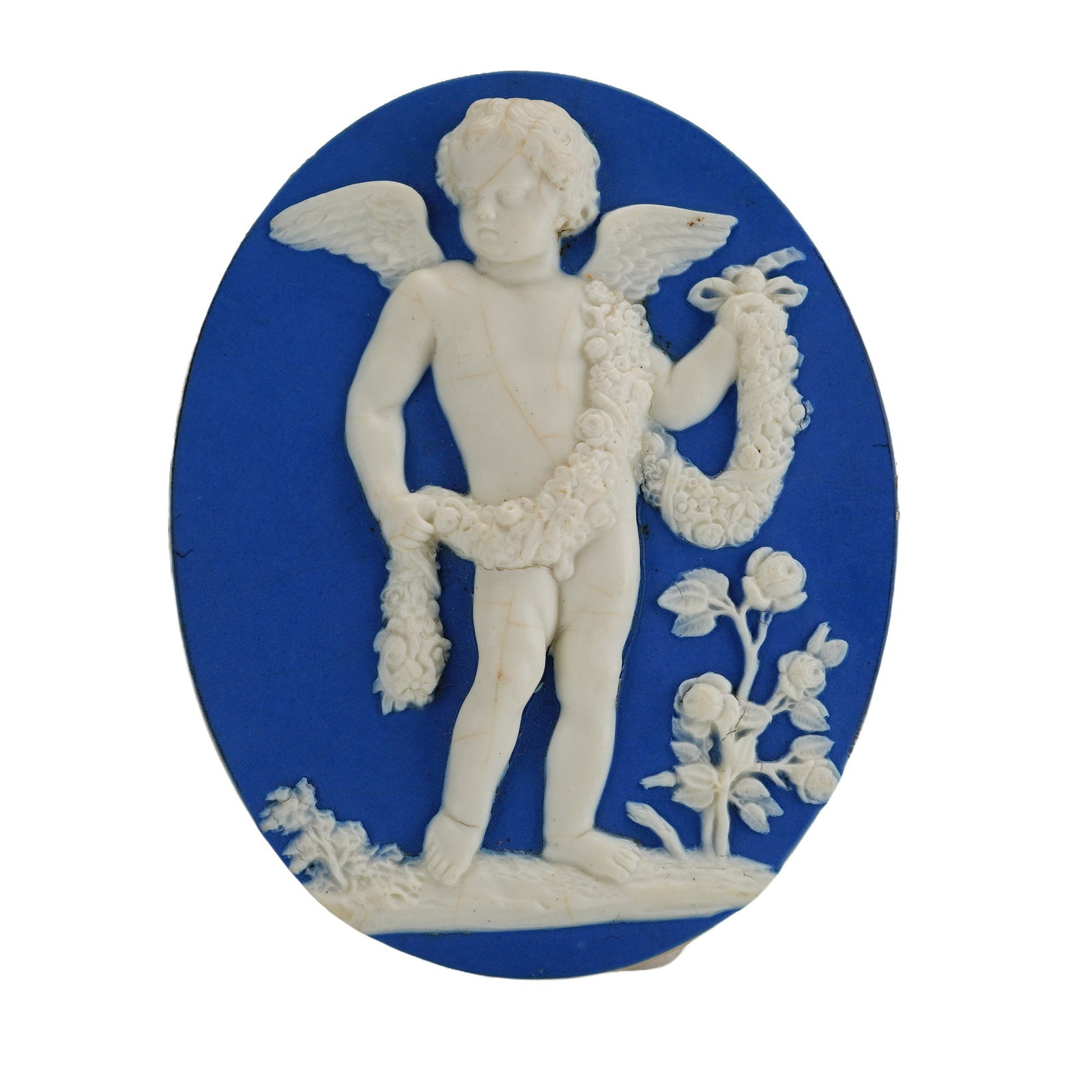 Wedgwood and Bentley Blue Jasperware Oval Plaque of Cupid with Floral Garland: A solid blue jasper dip stoneware oval plaque manufactured during the partnership of Josiah Wedgwood and Thomas Bentley. The piece features a white sprigged relief decoration depicting a winged Cupid 
