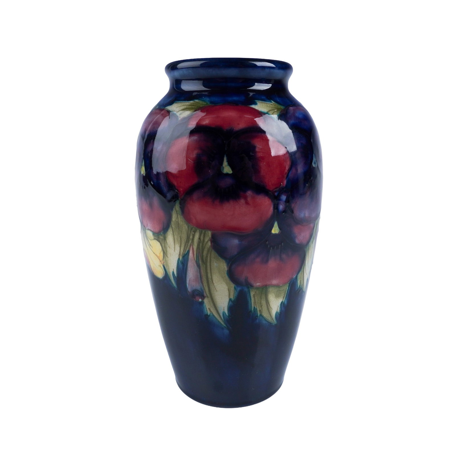 Moorcroft Pottery Pansy Vase: A stunning Moorcroft vase featuring the vibrant Pansy pattern. This hand painted piece displays vivid red and purple pansies with soft green leaves, set against a deep cobalt blue background. The vase
