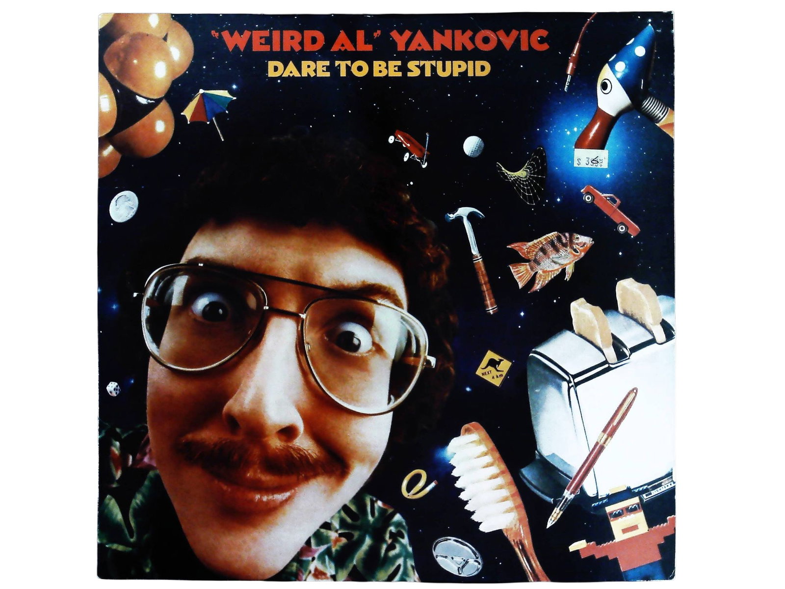 Weird Al Yankovic Dare To Be Stupid 1985 Vinyl LP Album: This is a single vintage vinyl LP album, Dare To Be Stupid, by Weird Al Yankovic, released in 1985 by Rock 'N' Roll Records. The album is a 12-inch black vinyl disc housed in a glossy cardboard sleeve