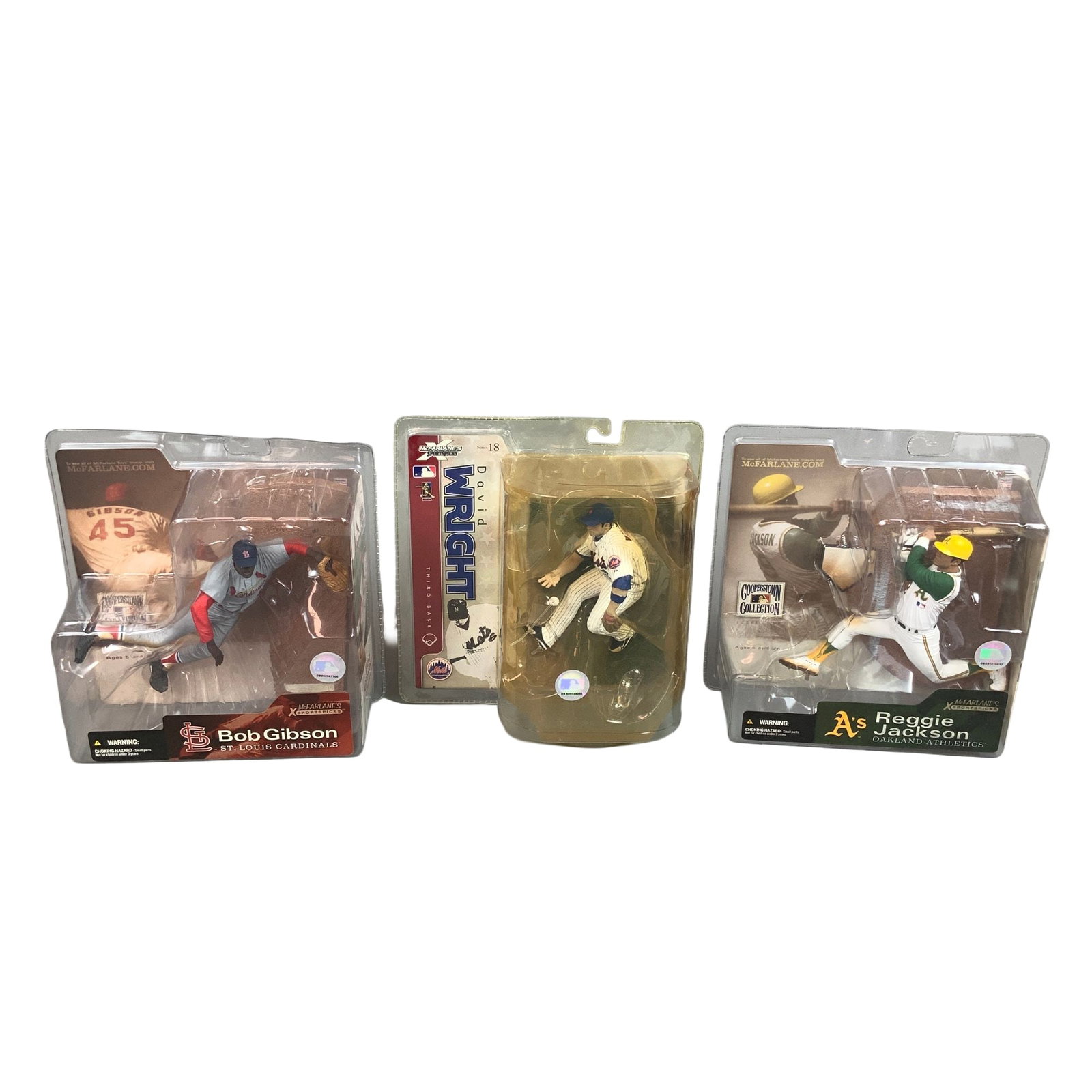 Three McFarlane Toys MLB Figurines in Boxes, Bob Gibson, David Wright, and Reggie Jackson: A collection of three factory-sealed sports action figurines produced by McFarlane Toys, representing prominent players from Major League Baseball. This lot, described as 3pc NFL figurines in boxes, i