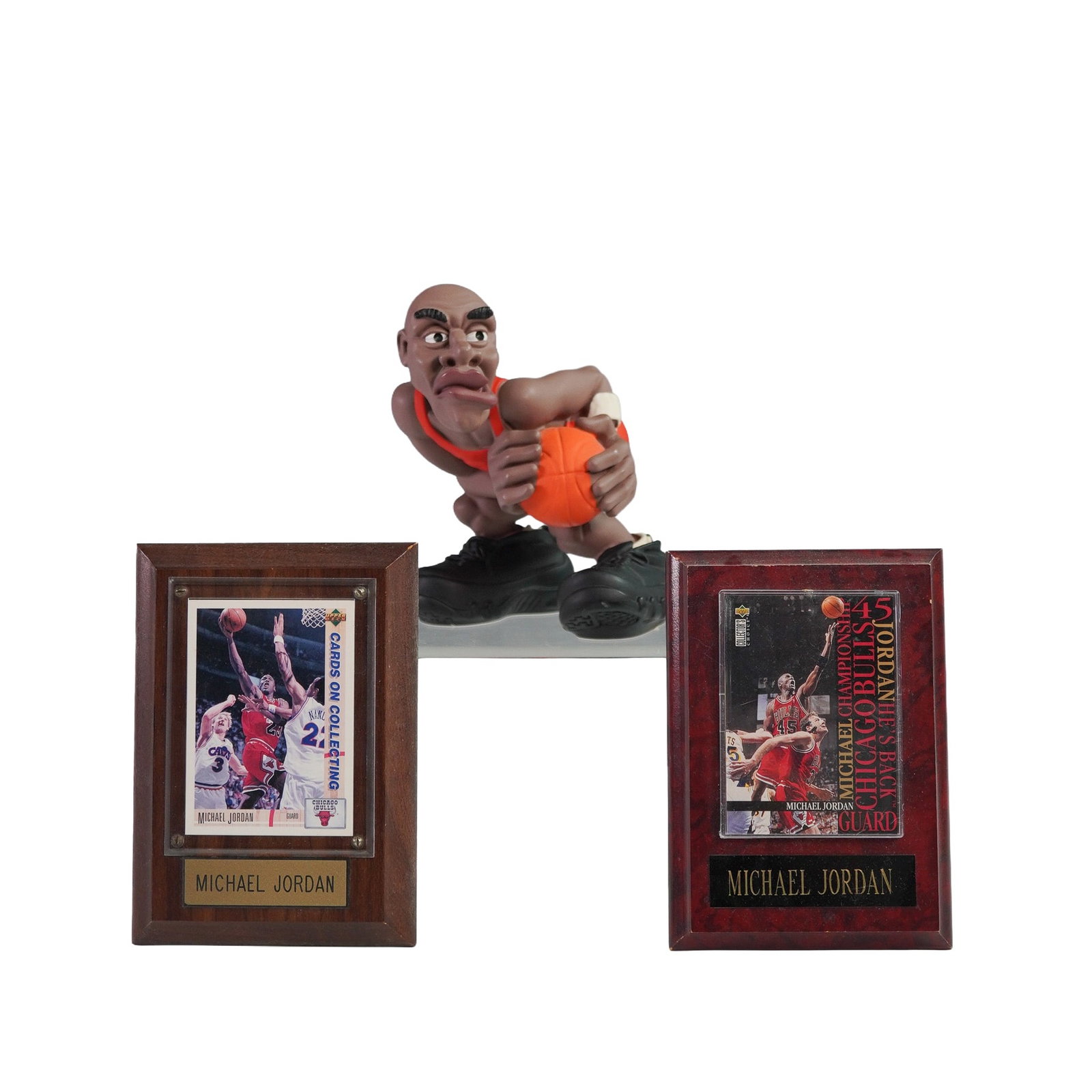 3pc Michael Jordan Lot, Plaque Cards & Basketball Figurine: Three-piece Michael Jordan collectible lot featuring two trading cards mounted on individual plaques and a stylized figurine of Jordan in action. The cards are preserved under clear acrylic on wooden 