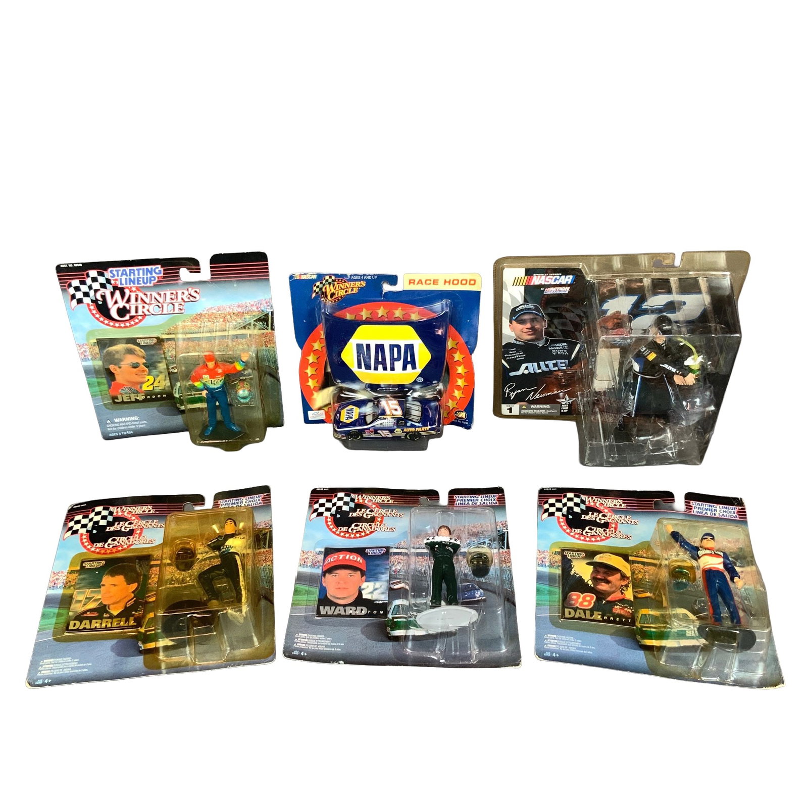 Six Winners Circle and NASCAR Action Figures & Model Cars: A collection of six NASCAR-themed collectibles featuring prominent drivers. The assortment consists of four Kenner Starting Lineup / Winner's Circle figures of Jeff Gordon, Darrell Waltrip, Ward Burto