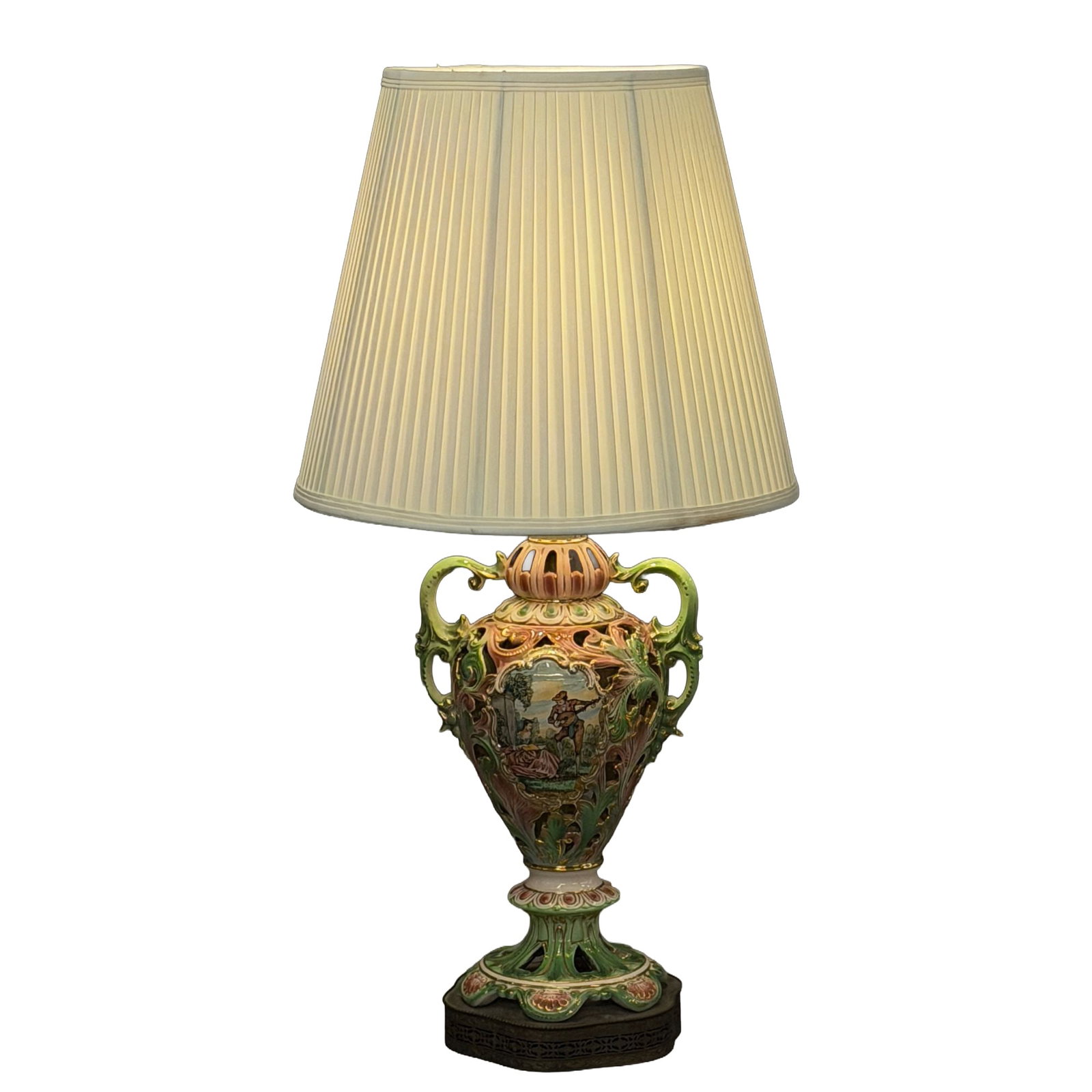 Ornate Reticulated Porcelain Table Lamp in the Capodimonte Style: This mid-20th-century decorative table lamp features an urn-form porcelain body mounted on a cast metal base. The ceramic base is reticulated with pierced openwork and finished in a palette of pink an