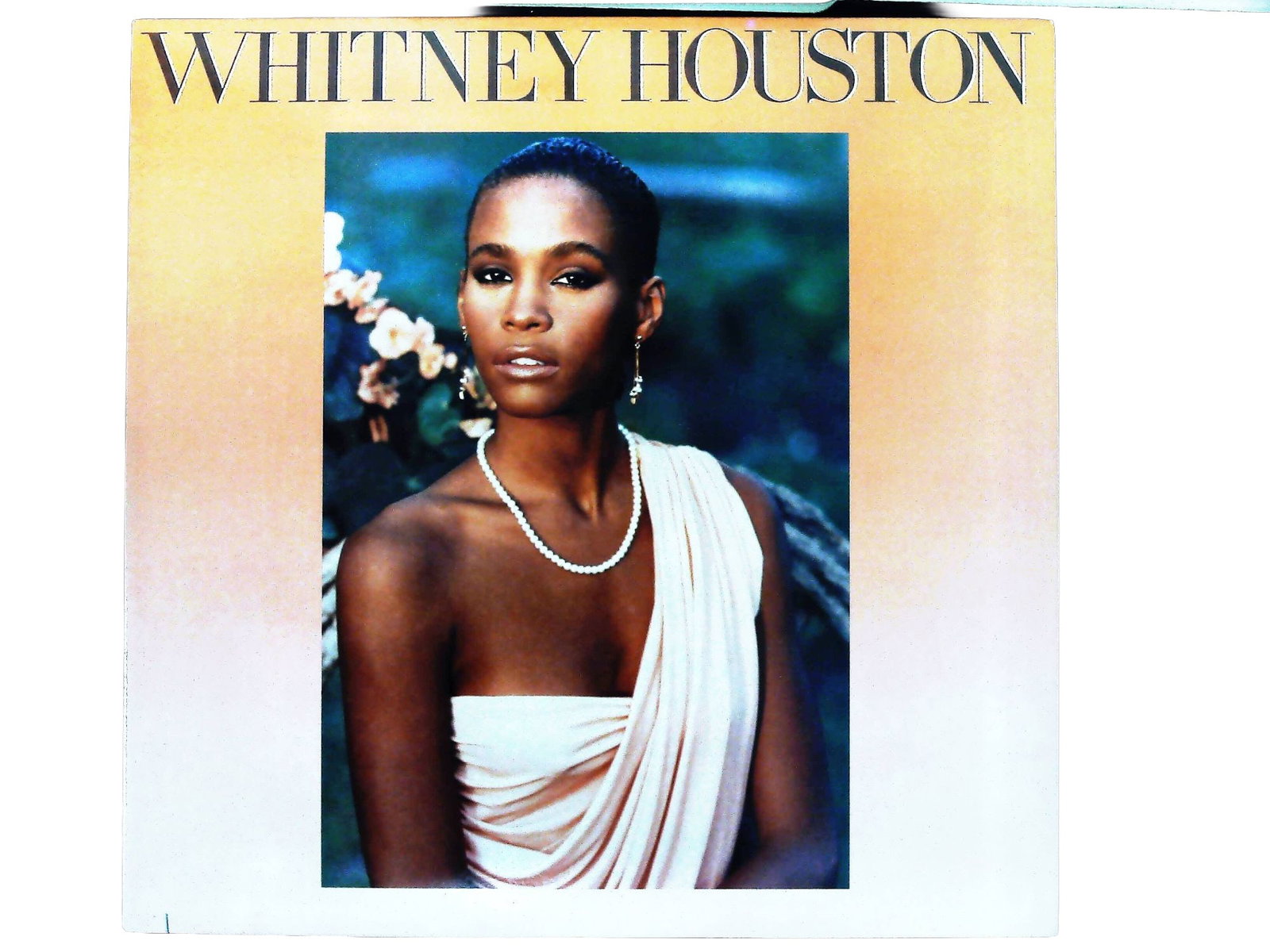Whitney Houston Self-Titled 1985 Arista Records Vinyl LP AL 8-8212: Whitney Houston self-titled debut studio album, released in 1985 by Arista Records under catalog number AL 8-8212. The lot includes the original cardboard sleeve and a 33 1/3 RPM vinyl LP. The front c