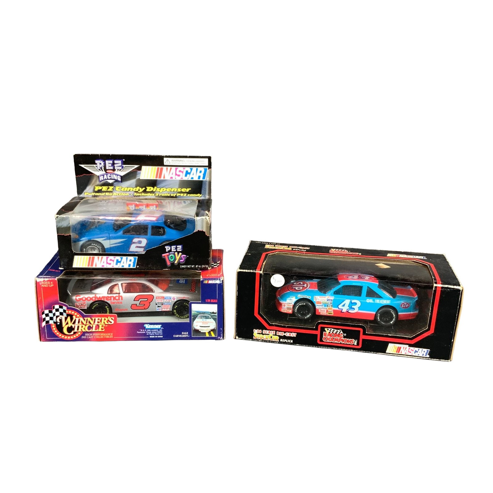 3pc NASCAR Die-Cast Model Cars, Dale Earnhardt, Richard Petty, Rusty Wallace.: This lot consists of three NASCAR-themed toy vehicles in their original packaging from various manufacturers. The first item is a Rusty Wallace PEZ Racing NASCAR PEZ Candy Dispenser produced by PEZ Ca