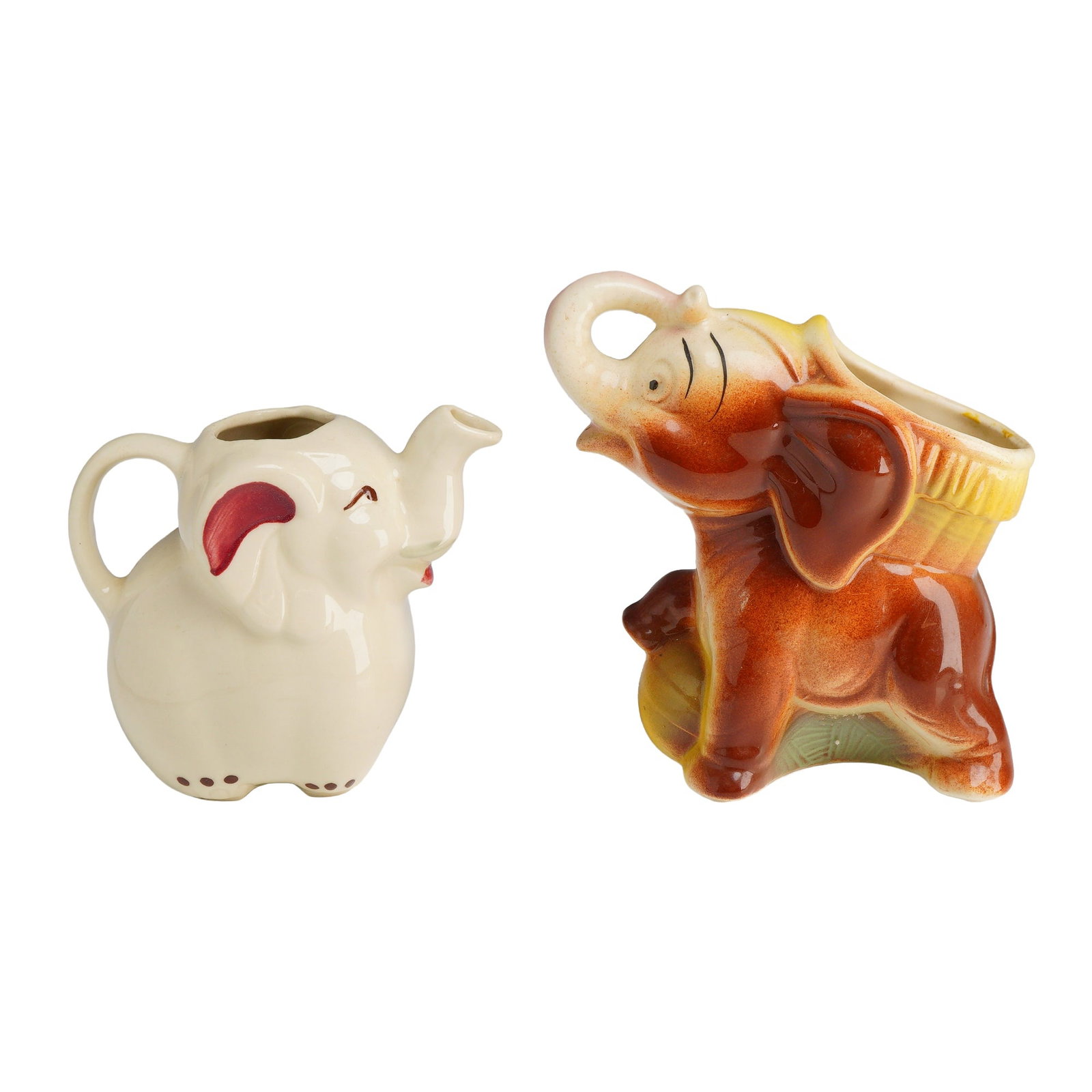 Shawnee Pottery Elephant Basket Planter and Jug: This lot features a pair of mid-century ceramic novelties produced by Shawnee Pottery. The first item is an anthropomorphic elephant-shaped creamer or jug, finished in an off-white gloss glaze with ha