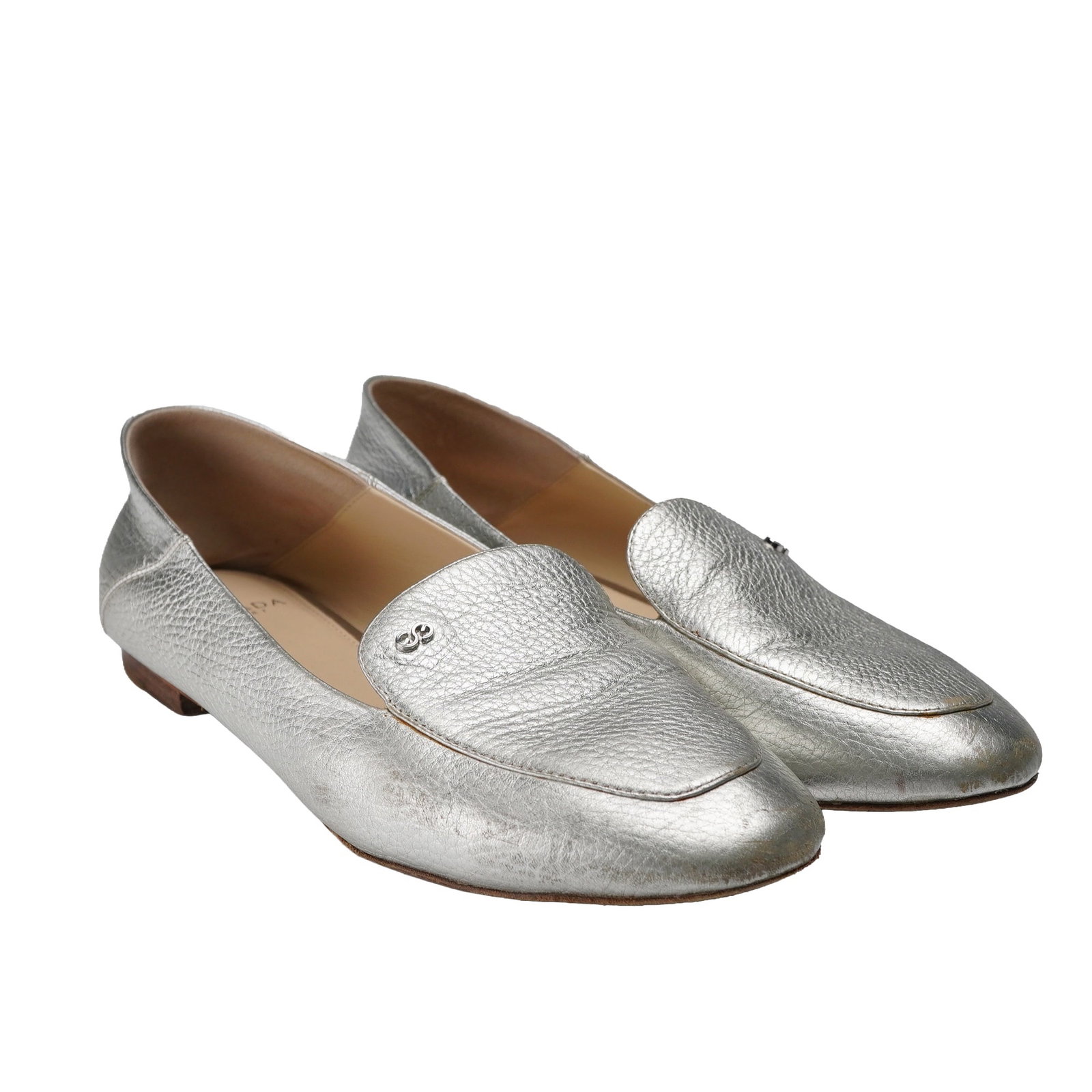 Pair of Escada Sport Leather Silver Flats: A pair of Escada Sport Silver Flats. These women's slip-on loafers feature a metallic silver-colored, textured leather finish. Each shoes upper is adorned with a small, metallic double-circle emblem. 
