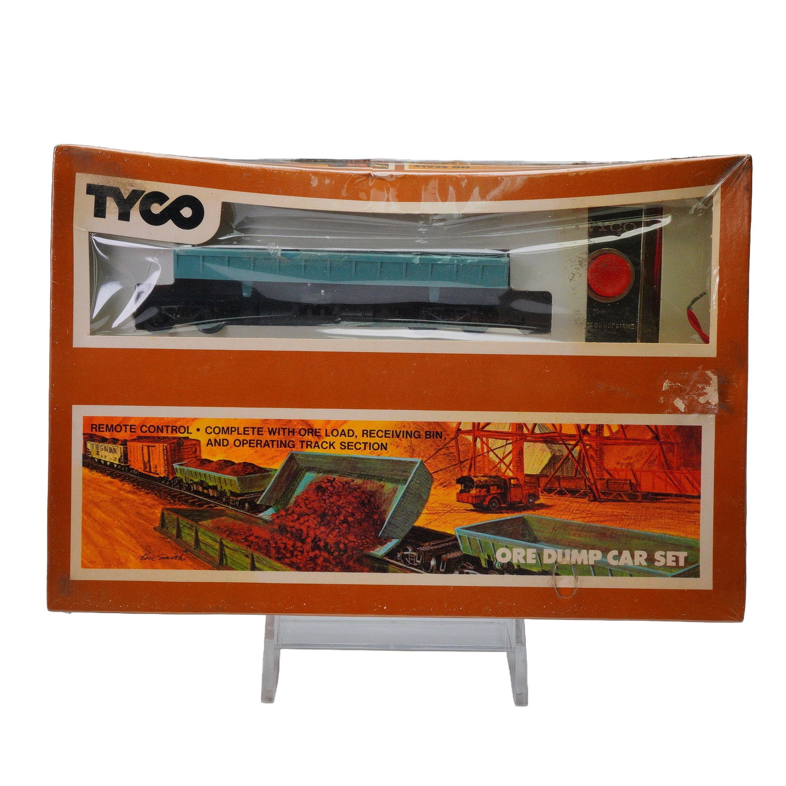 Tyco HO Scale Ore Dump Car Set: Vintage Tyco Ore Dump Car Set, complete with remote control, ore load, receiving bin, and operating track section, all housed in its original orange and white retail box. The front of the box features