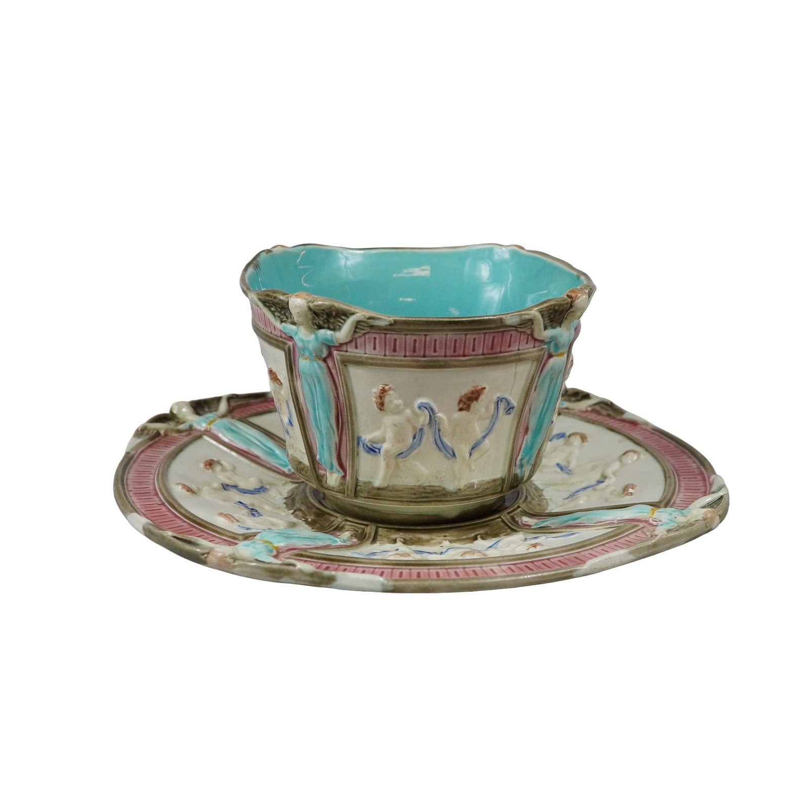 Wedgwood Majolica Neoclassical Relief Molded Cup and Saucer: This set consists of a late 19th-century Wedgwood majolica handleless cup and matching saucer featuring relief-molded neoclassical motifs. The cup is decorated with four rectangular panels, each depic