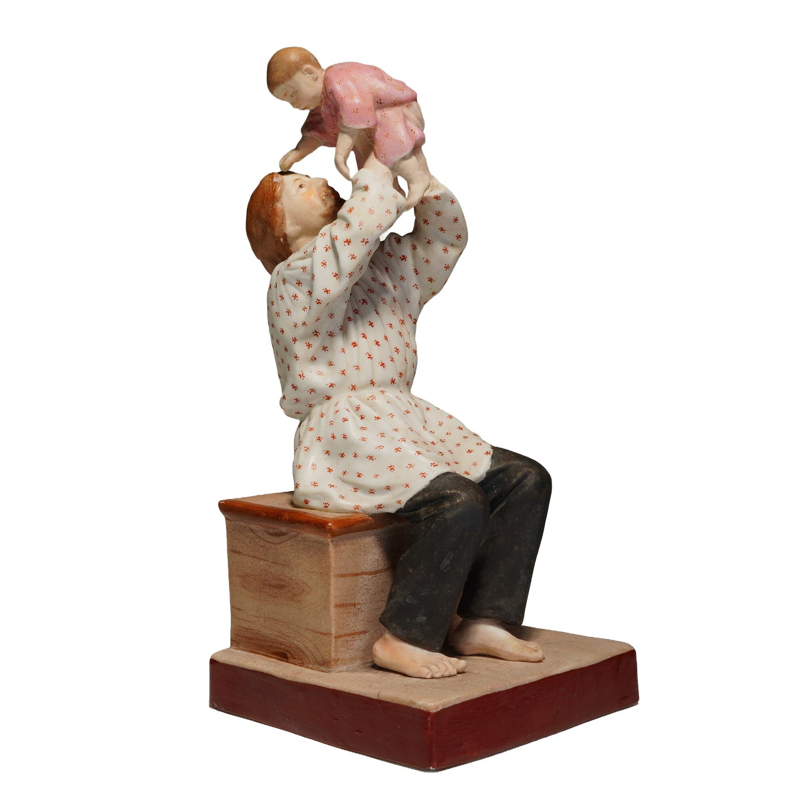 Gardner Imperial Russian Porcelain Figurine, Father and Child: A figurine portraying a father lifting his child in a tender embrace. This hand-painted piece features the father dressed in a white top with red floral patterns, while the child is depicted in a soft