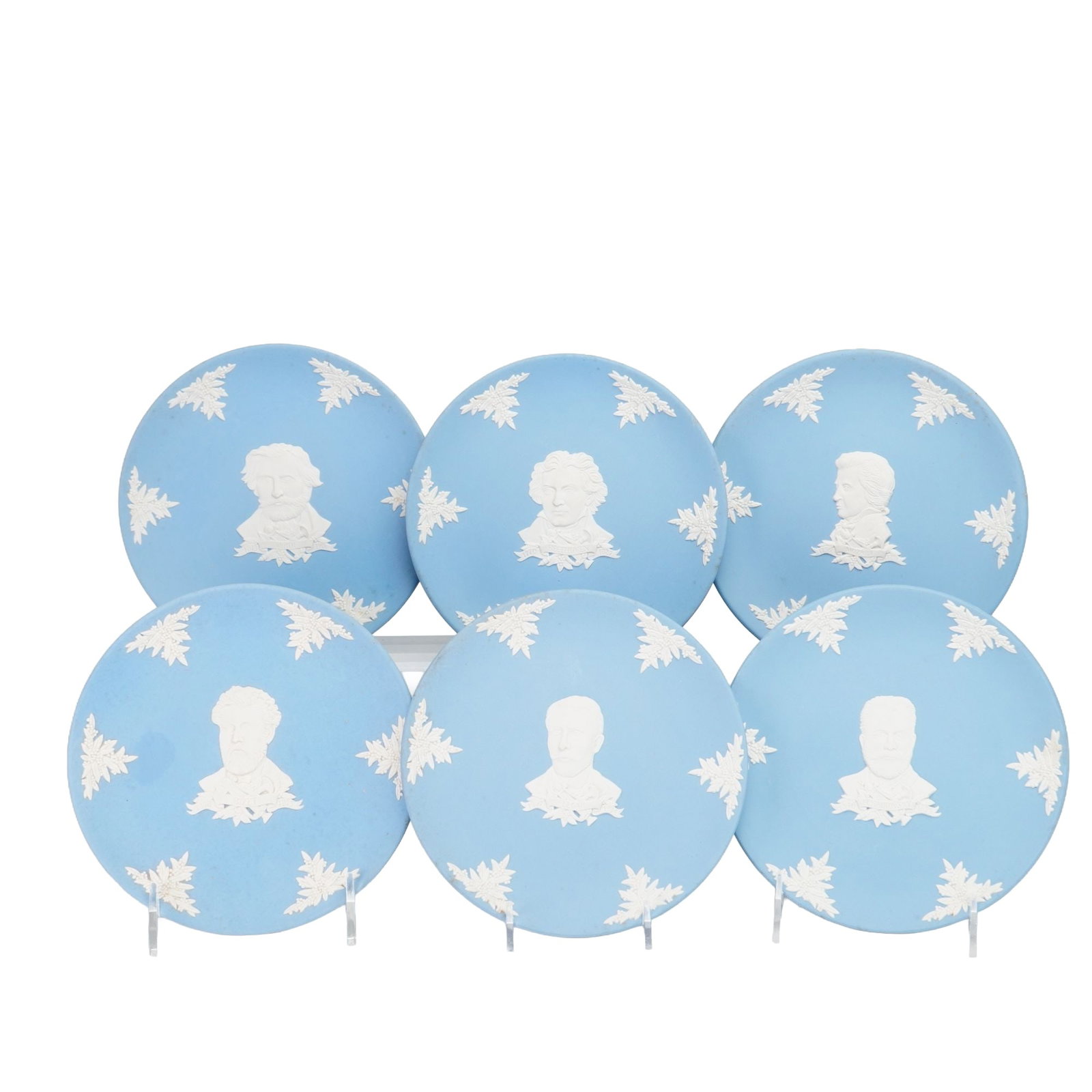 Set of Six Wedgwood Blue Jasperware Great Composers Plates: A set of six circular cabinet plates manufactured by Wedgwood in England. These items are constructed from light blue jasperware, a matte-finish unglazed stoneware. Each plate features a central white