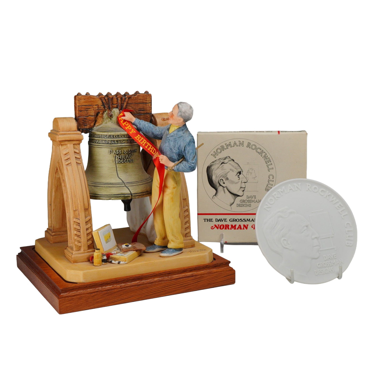 Lot of 2 Norman Rockwell Pieces Including Numbered Celebration Figurine and Membership Plaque with: This lot consists of two commemorative Norman Rockwell items. The first is a hand-painted ceramic figurine titled Celebration, which depicts the artist Norman Rockwell standing beside the Liberty Bell