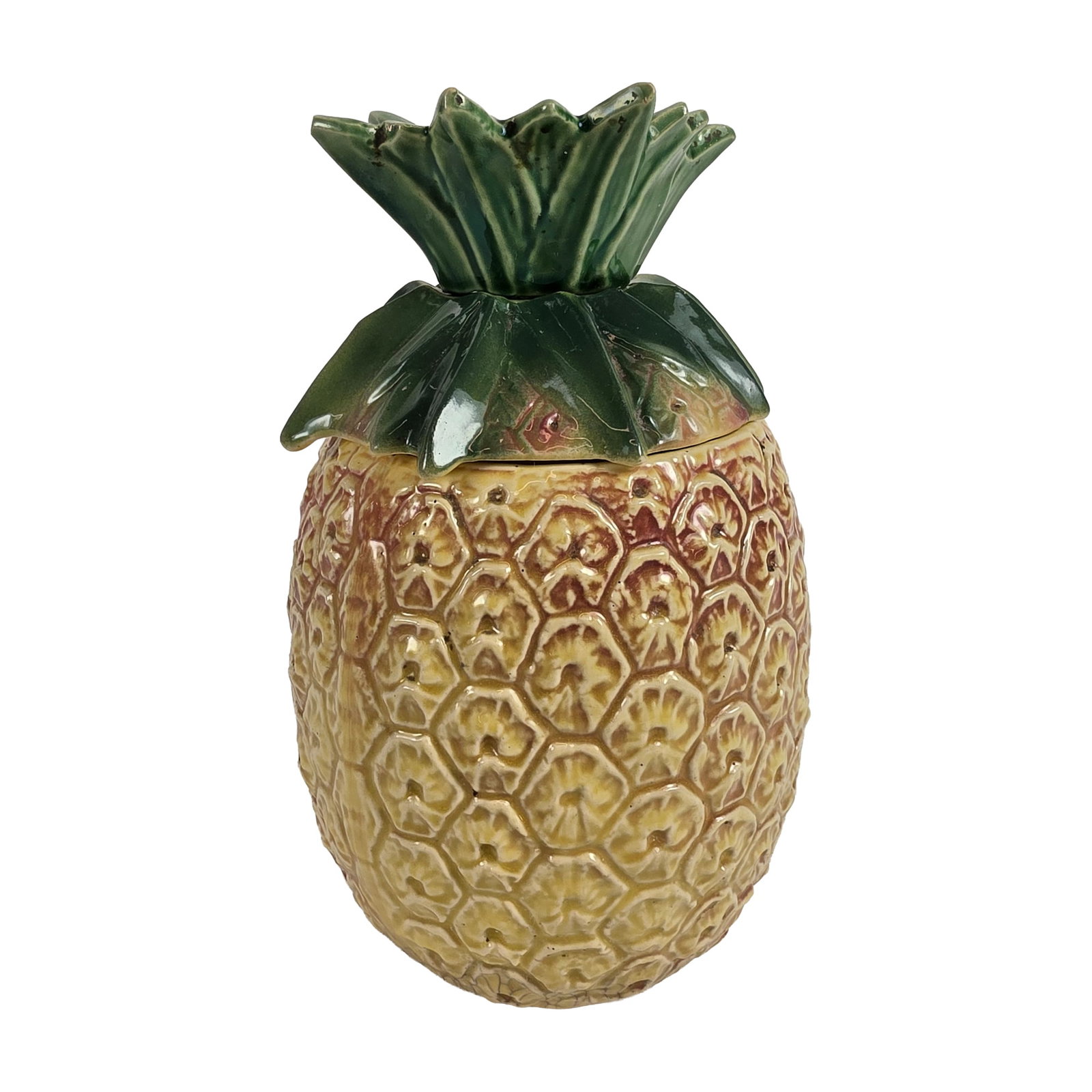 McCoy Ceramic Pineapple Cookie Jar: Earthenware construction consisting of a base with relief-molded hexagonal texture and a lid modeled as a green leafy crown. Finished in a honey-yellow and green multi-color glaze with heavy
