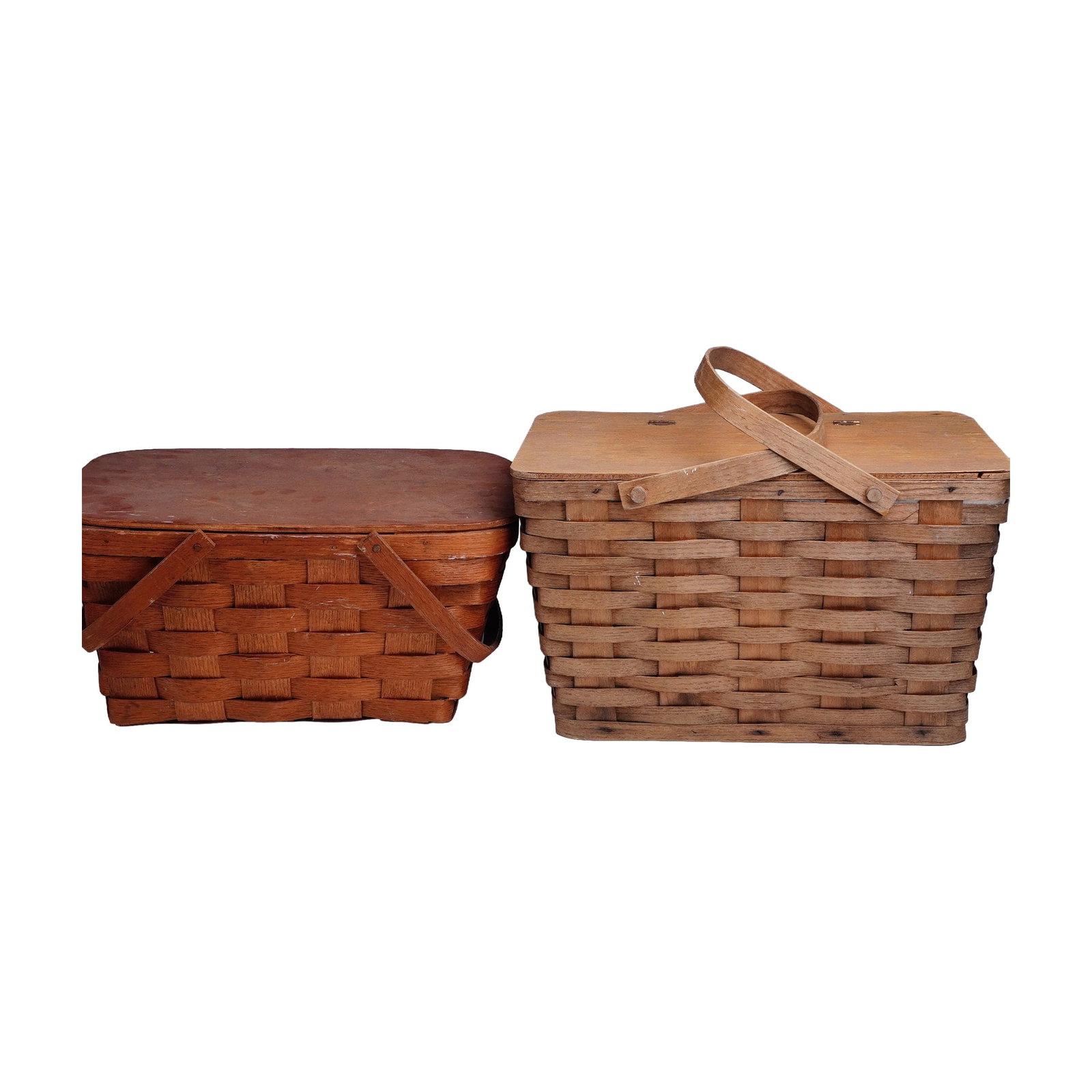 Pair of Vintage Woven Picnic Baskets, One with Plastic Serviceware: A charming pair of vintage lidded picnic baskets, both constructed in classic woven wood slat form with hinged lids and wooden swing handles. One basket retains a warm reddish-brown finish, while the 