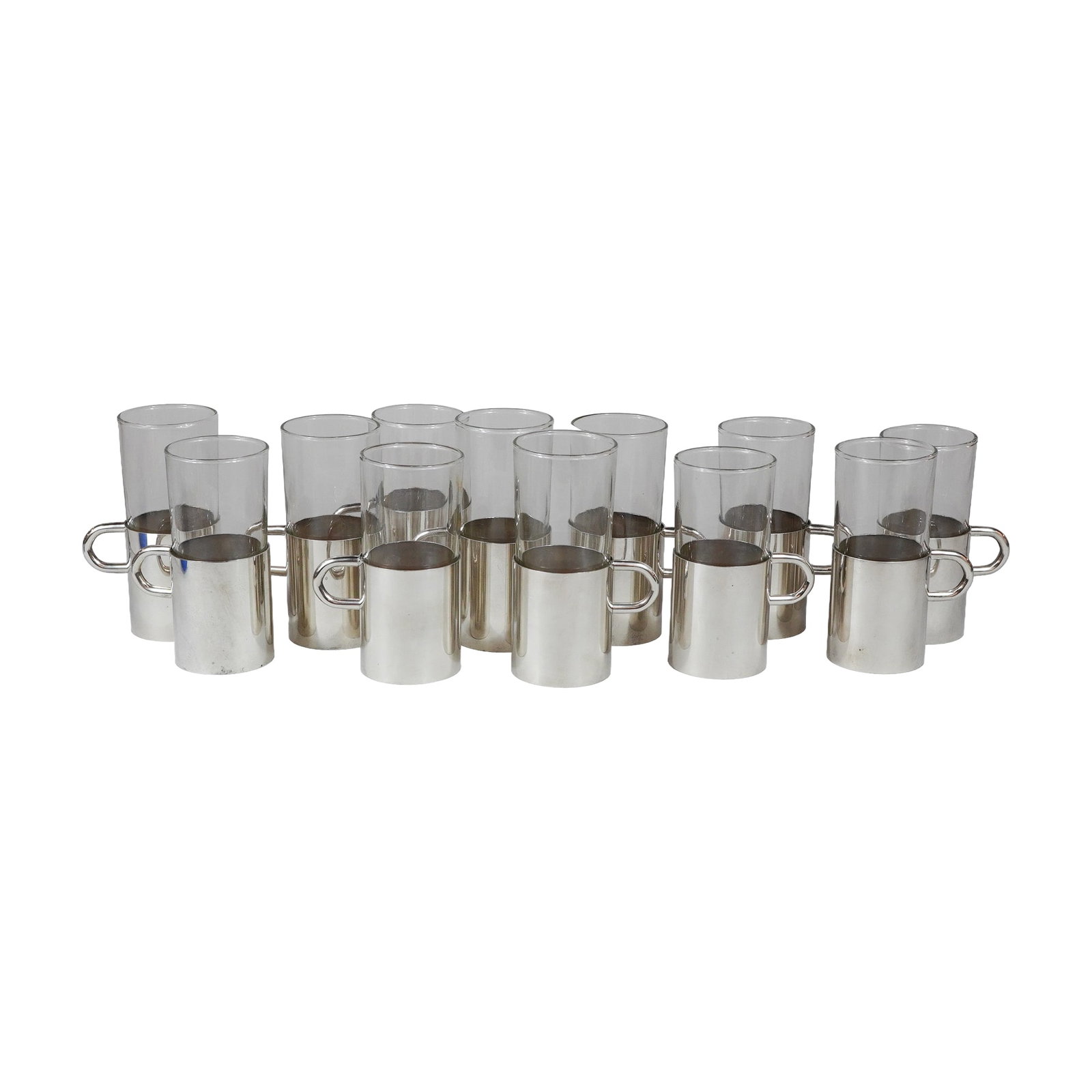 12pc Mid-Century Modern Silver-Plated Sleeves with Glass Cup Inserts: This set consists of twelve cylindrical clear glass drinking vessels, each paired with a removable silver-plated metal sleeve. The 12pc silverplate sleeve with glass cup insert set reflects a mid-cent