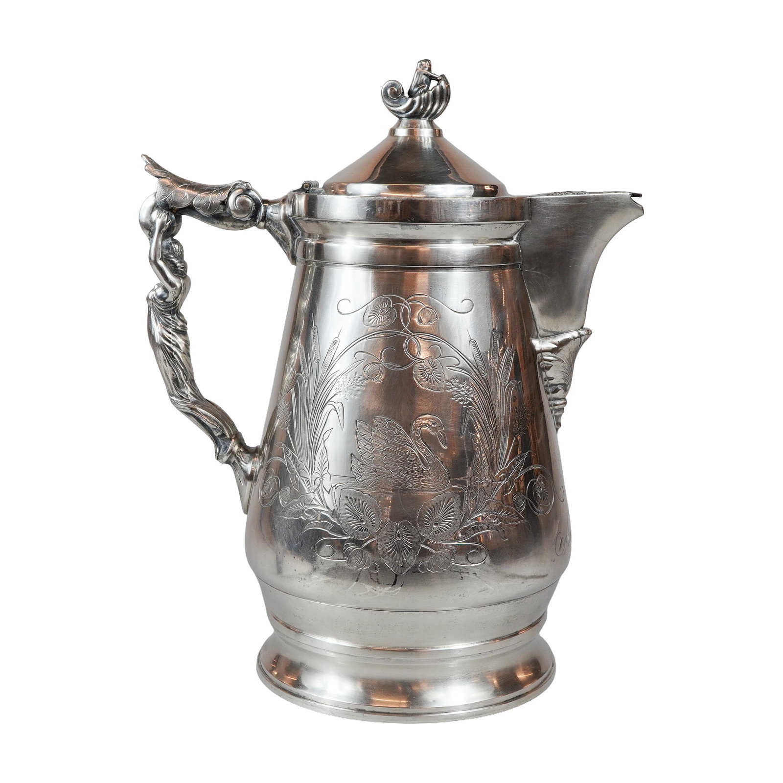 Wilcox Quadruple Silver-Plate Ice Water Pitcher: A Wilcox Silver Plate Co. quadruple-plated figural ice water pitcher, model 317. The vessel features a tapered form engraved with a naturalistic scene of a swan amid cattails, water lilies, and other 
