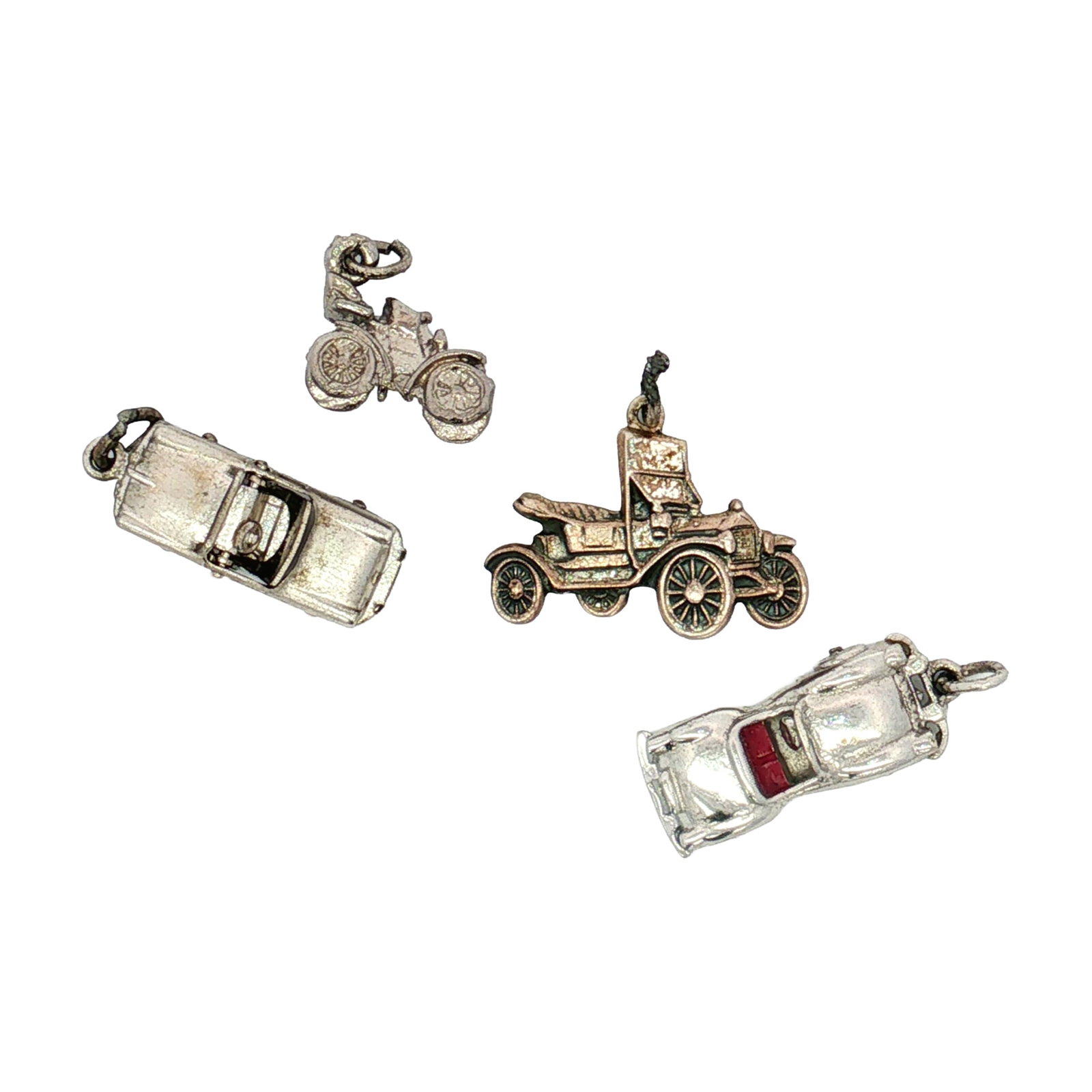 4pc Sterling and Non-Sterling Silver Vintage Cars Charms: A collection of miniature silver charms modeled after cars, including two convertibles, and a Model T. One charm is marked Sterling. Dimensions: 1"L x 0.5"H Weight: 14.33 g