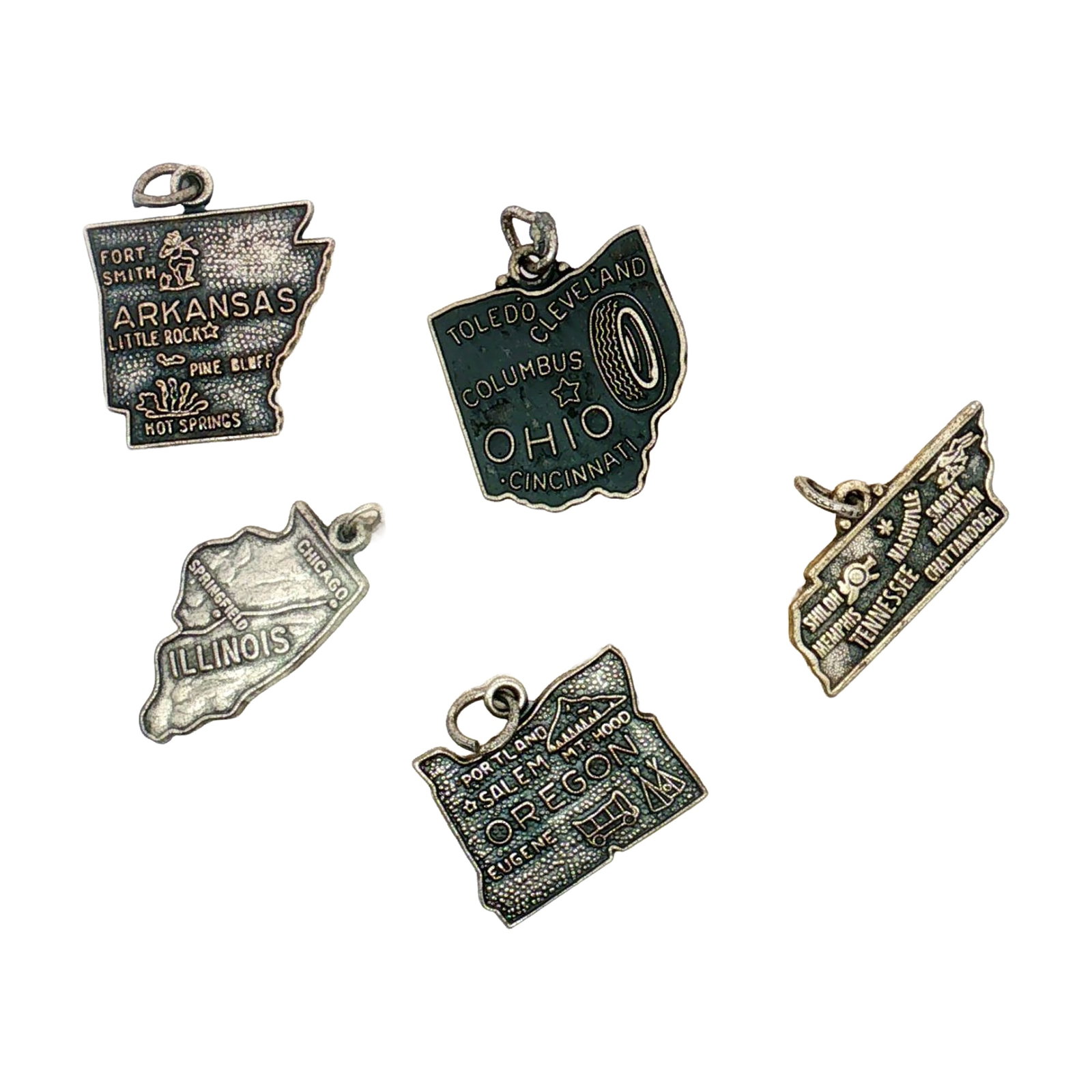 5pc Sterling Silver and Silver-Plated U.S. States Souvenir Charms: This collection of silver charms are modeled after U.S. states, including Illinois, Ohio, Oregon, Arkansas, and Tennessee. Most charms are marked Sterling. Dimensions: 0.75"L x 0.75"H Weight: 12.28 g