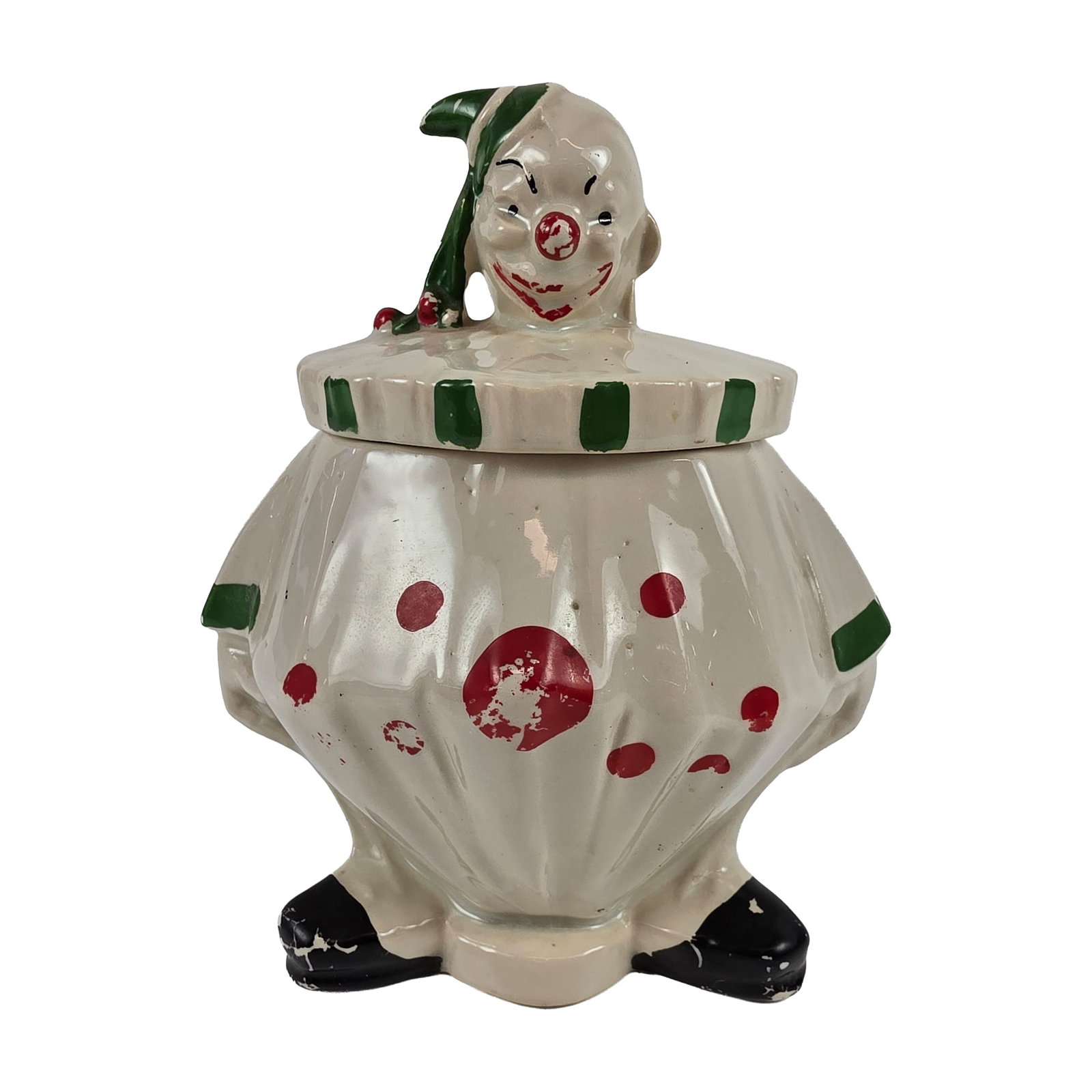 McCoy Happy Clown Ceramic Cookie Jar: The two-piece vessel is modeled in the form of a seated clown with a winking expression and pointed hat, featuring a wide ruffled collar and rounded, pleated body. The piece is finished with hand-pain