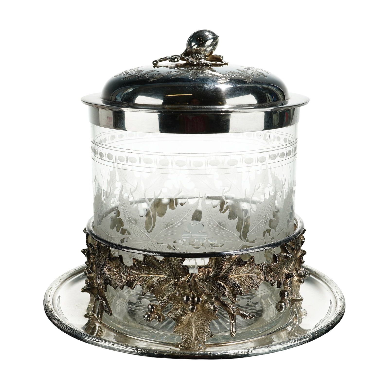 Sterling Silver and Glass Biscuit Box: This biscuit box features a clear glass body decorated with frosted leaf motifs around the exterior, while a band of etched dot decoration encircles the upper section beneath the rim. The box is fitte