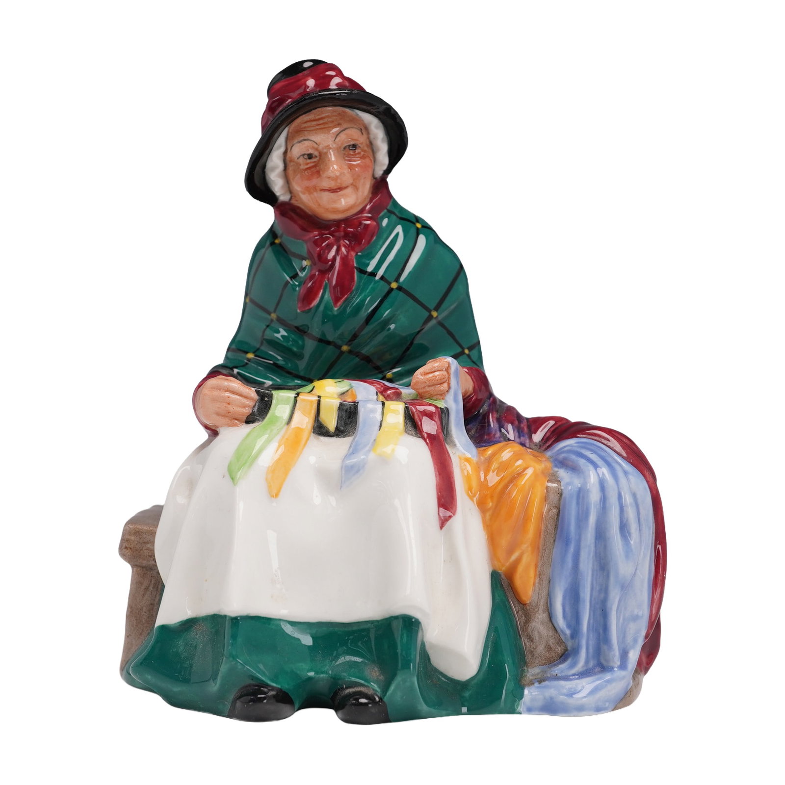 Royal Doulton Figurine, Silks and Ribbons HN2017: A Royal Doulton porcelain figurine titled Silks and Ribbons HN2017, designed by the renowned Leslie Harradine. This finely hand-painted piece depicts a seated woman in a vibrant red dress with a green