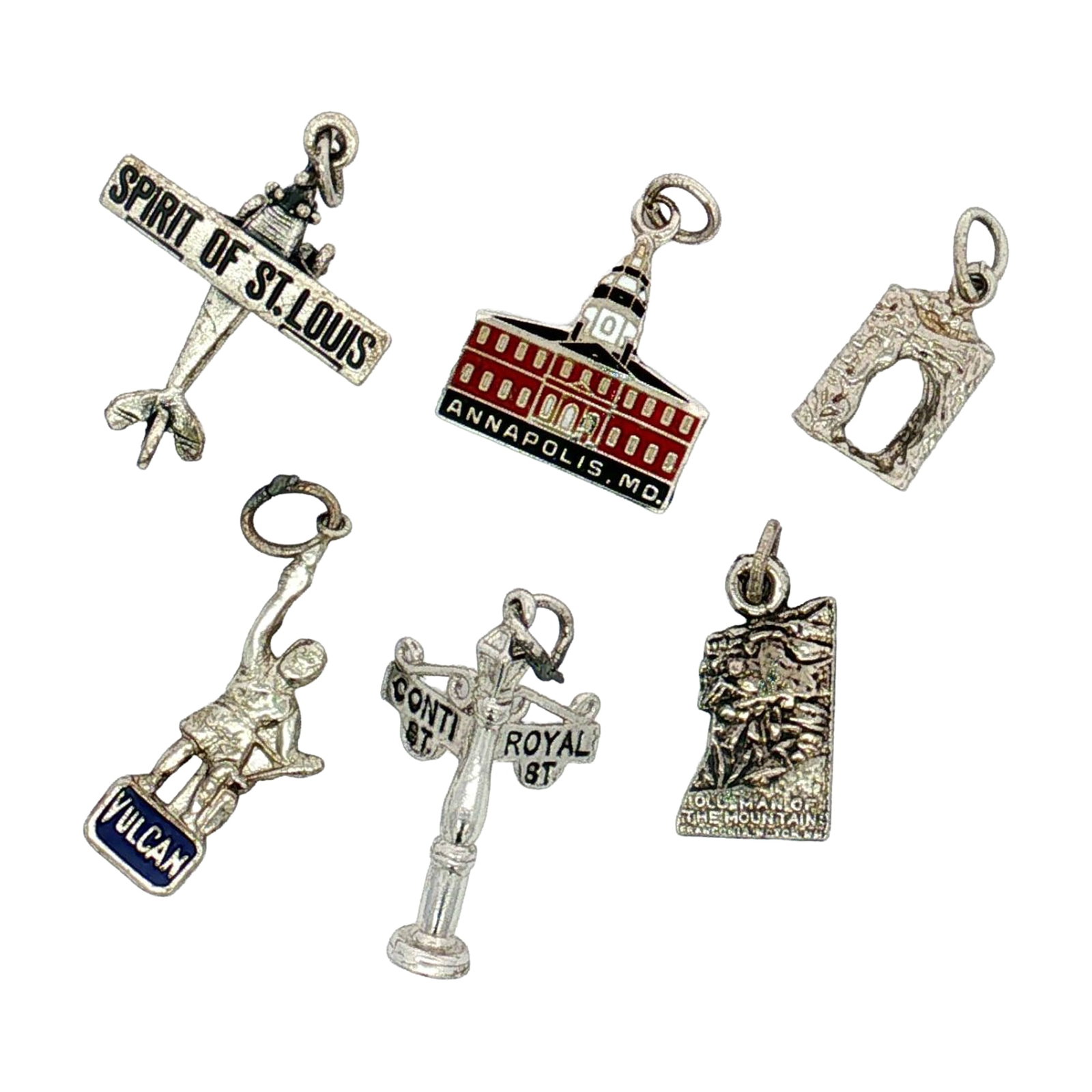 6pc Sterling and Non-Sterling Silver Miniature U.S. Landmarks and Locations Charms: A group of silver charms depicting various U.S. landmarks and locations. The set includes an enameled charm depicting the Maryland State House, a New Orleans street sign, the Old Man of the Mountain, 