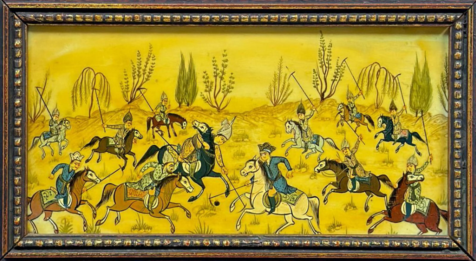 Framed Miniature Painting of a Persian Polo Match on Board: This Persian style miniature painting depicts a spirited polo match, a traditional theme known as chaugan. The central composition features twelve horsemen in traditional attire, including turbans and